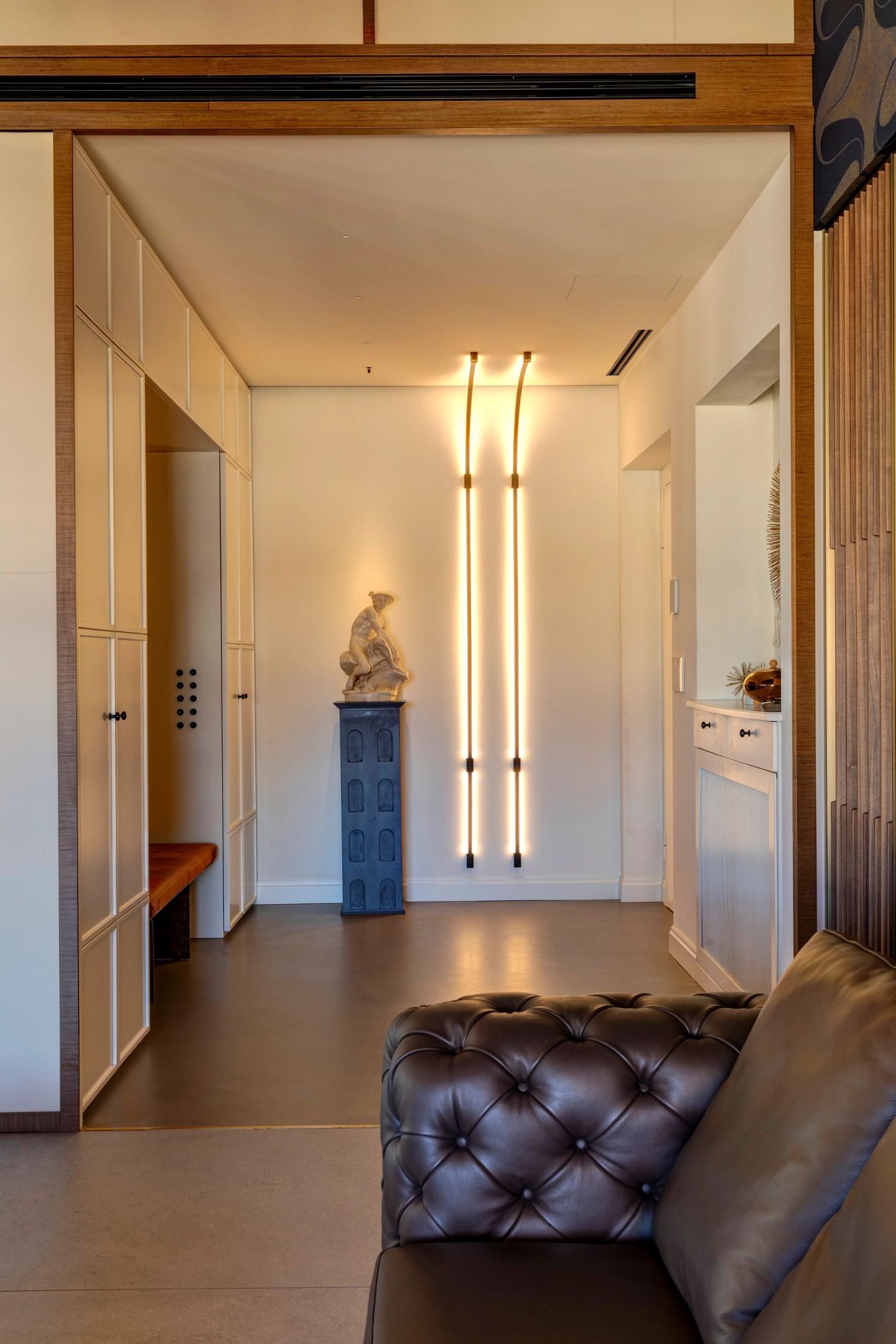 Tufted leather bench against the panelled wall of the entrance