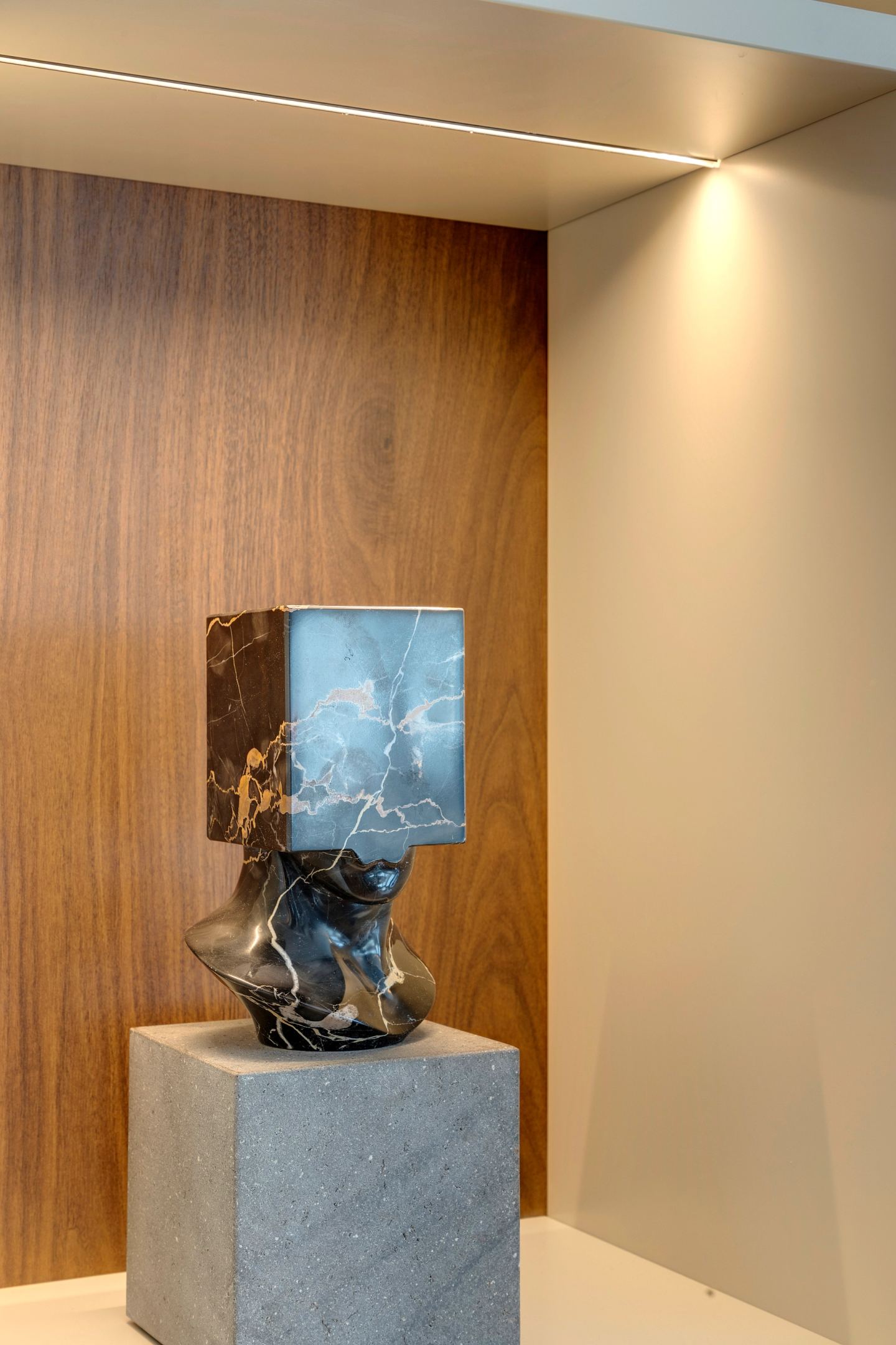 Marble lamp on a stone plinth against walnut