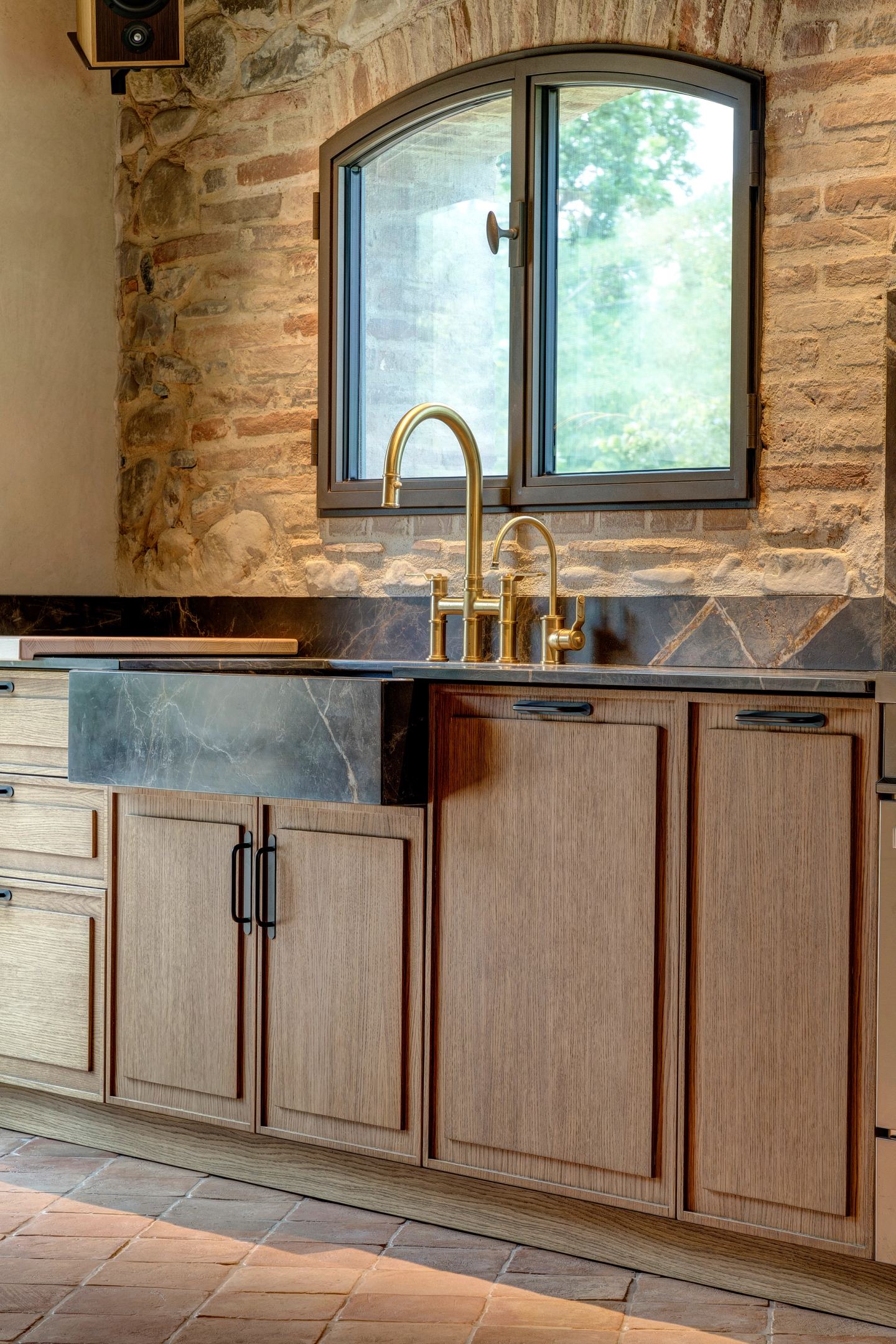 The sink run under the window, brass against stone