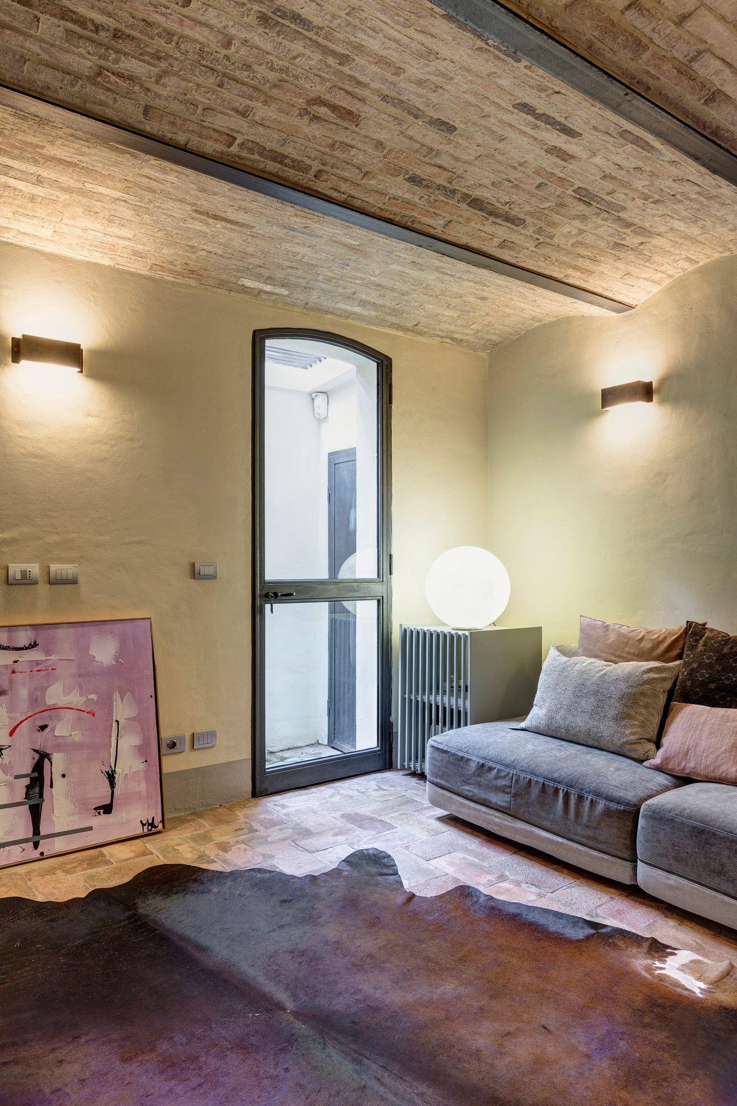 La sala TV verso la porta sul giardino, il mobile cannettato accanto al divano