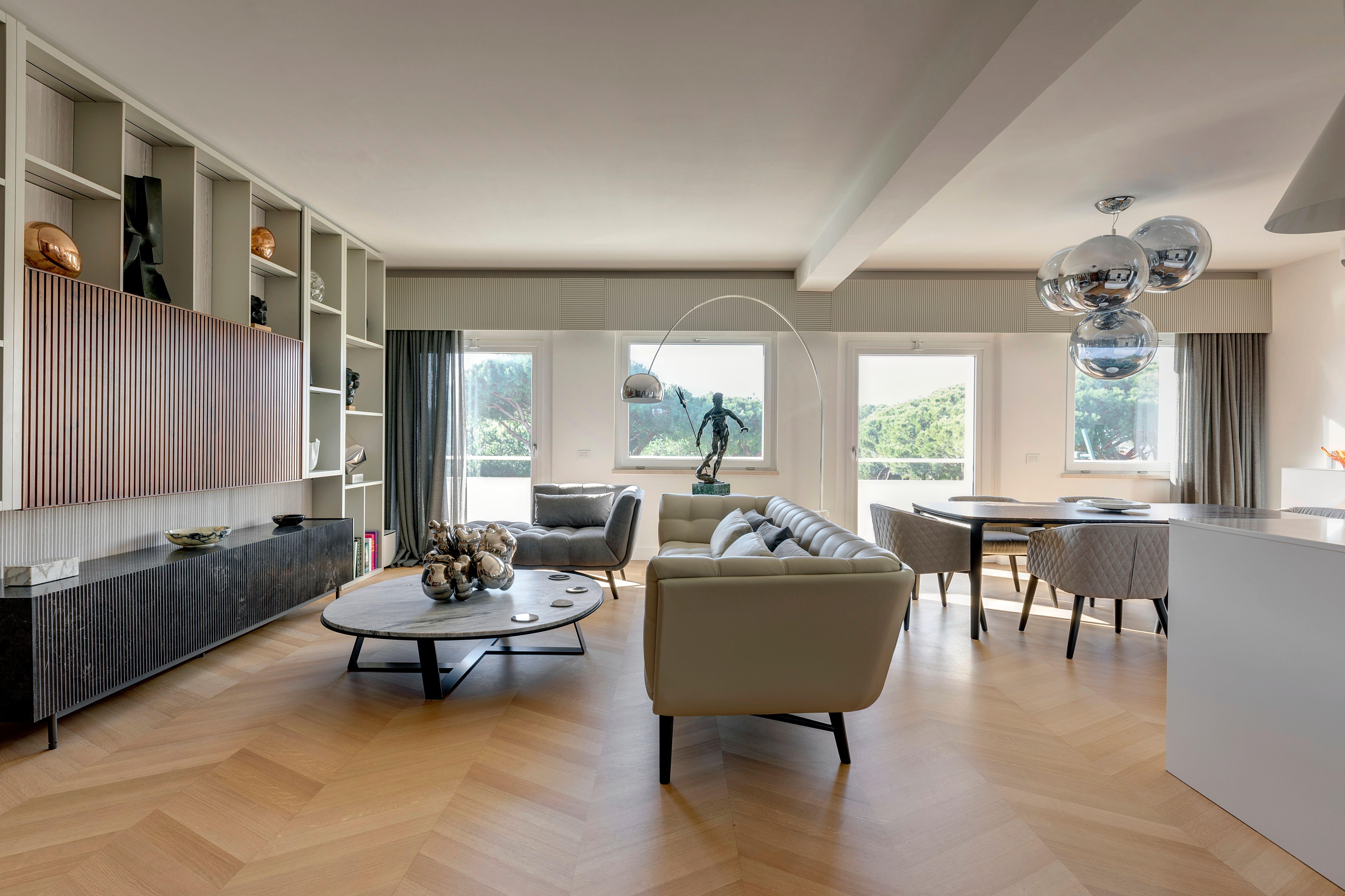 Living room seen from the entrance, herringbone oak floor running the length of the room