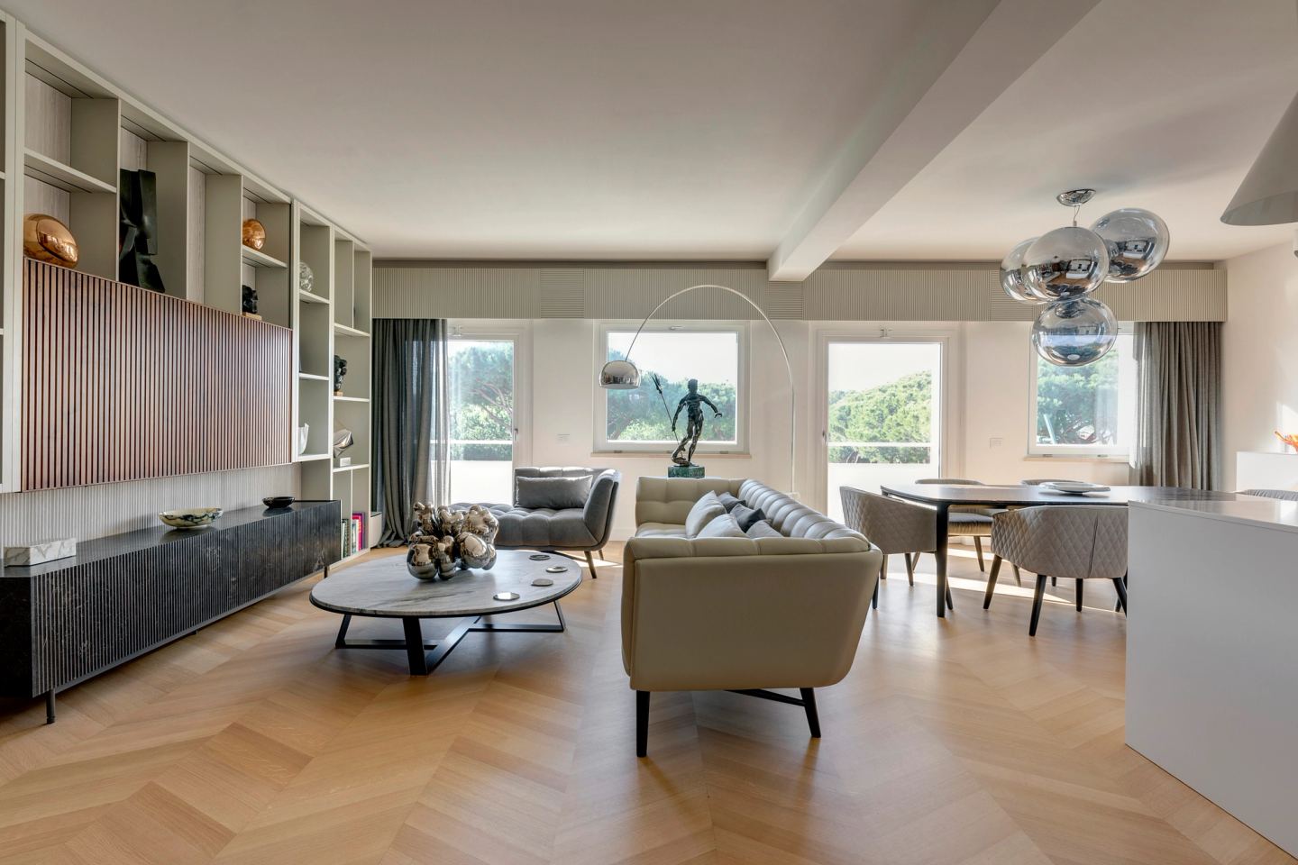 Living room seen from the entrance, herringbone oak floor running the length of the room