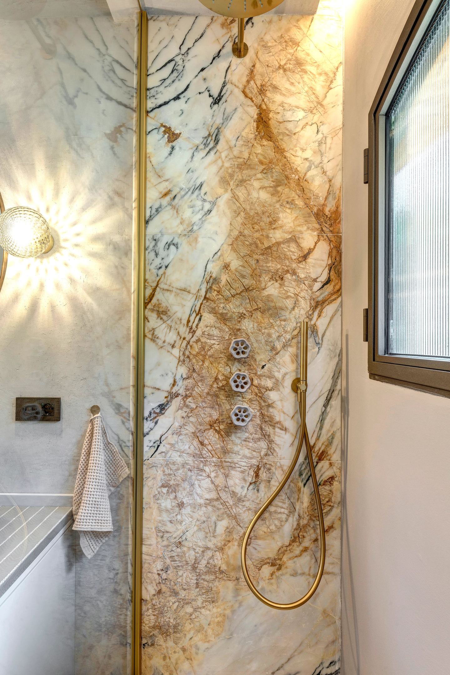 The shower cut into the marble beside the window