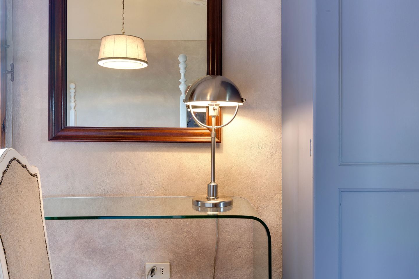 A wall light bent over the headboard