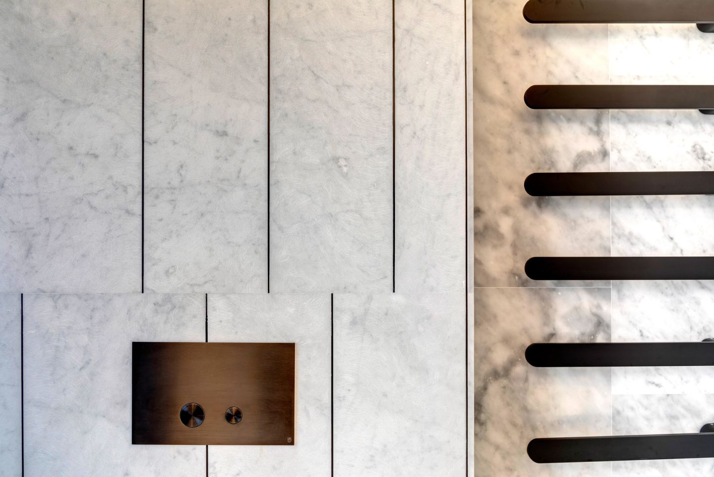 Bronze flush plate set into the marble, heated rail beside it