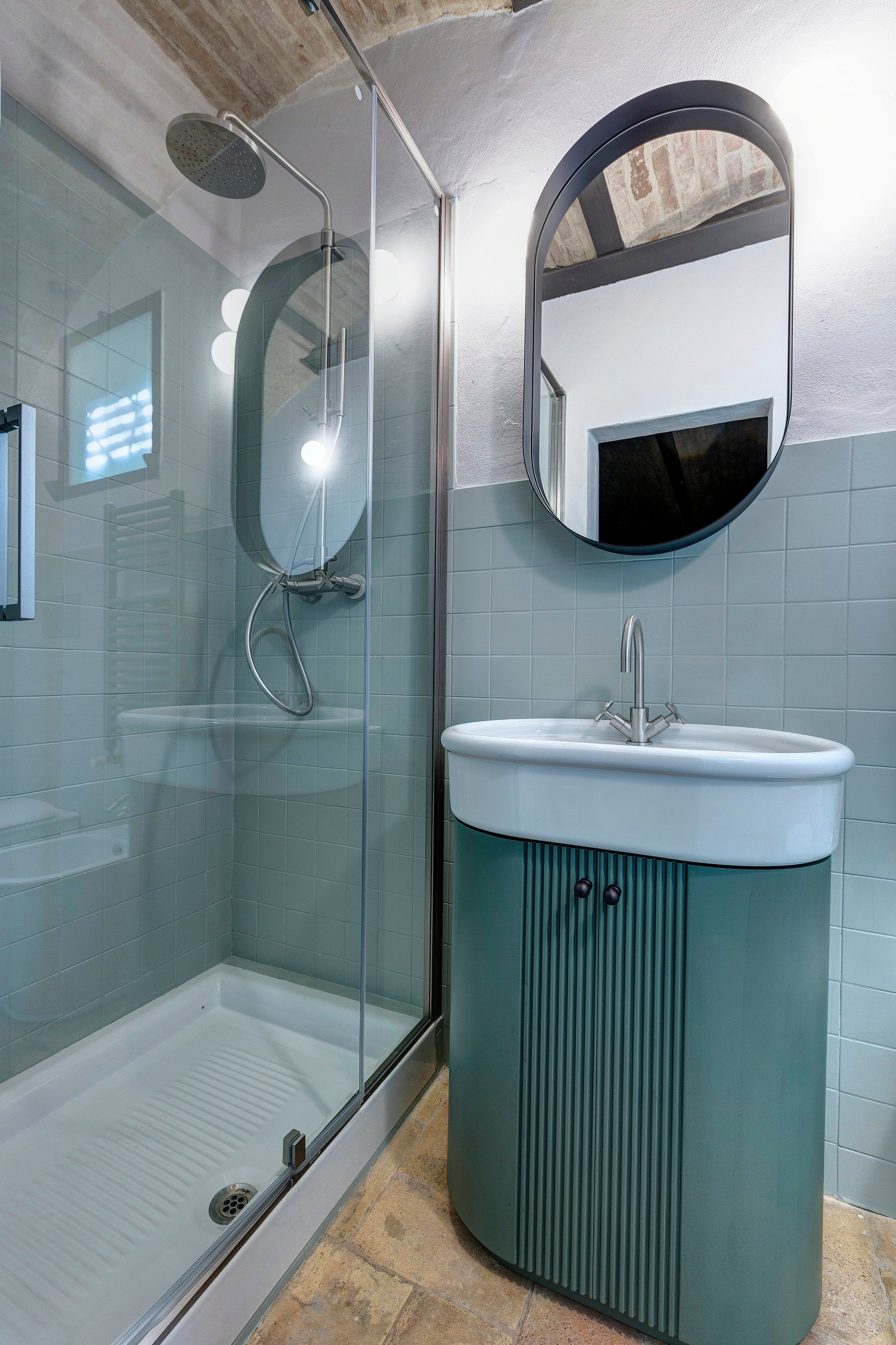 The shower, the cabinet and the oval mirror