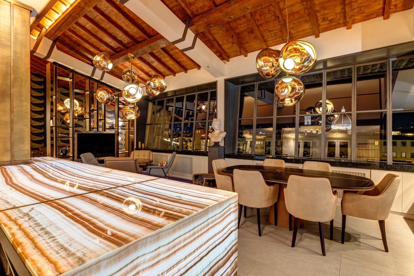 Onyx counter and dining chairs under the beams at night