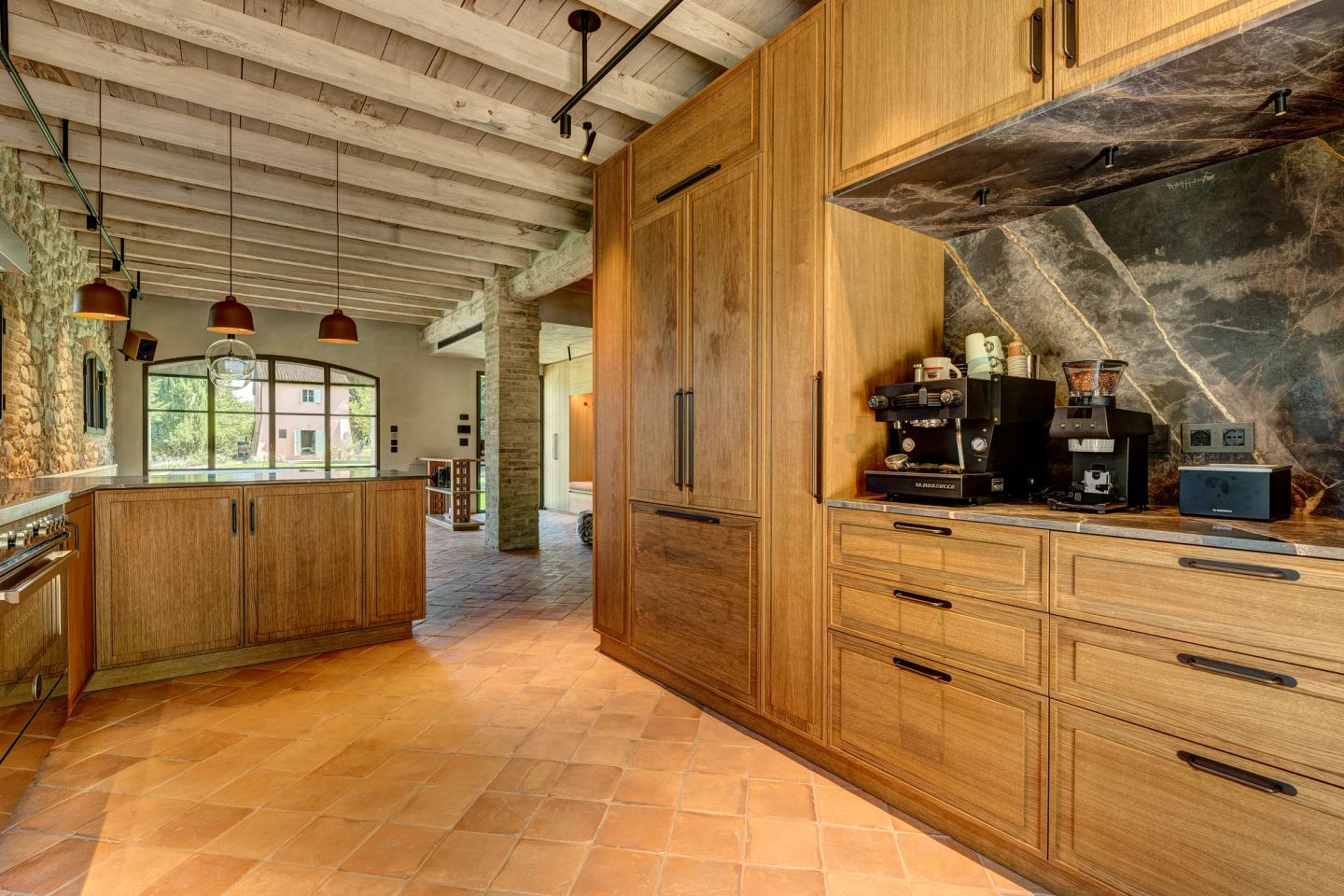 The kitchen seen from the open floor, machines on the counter