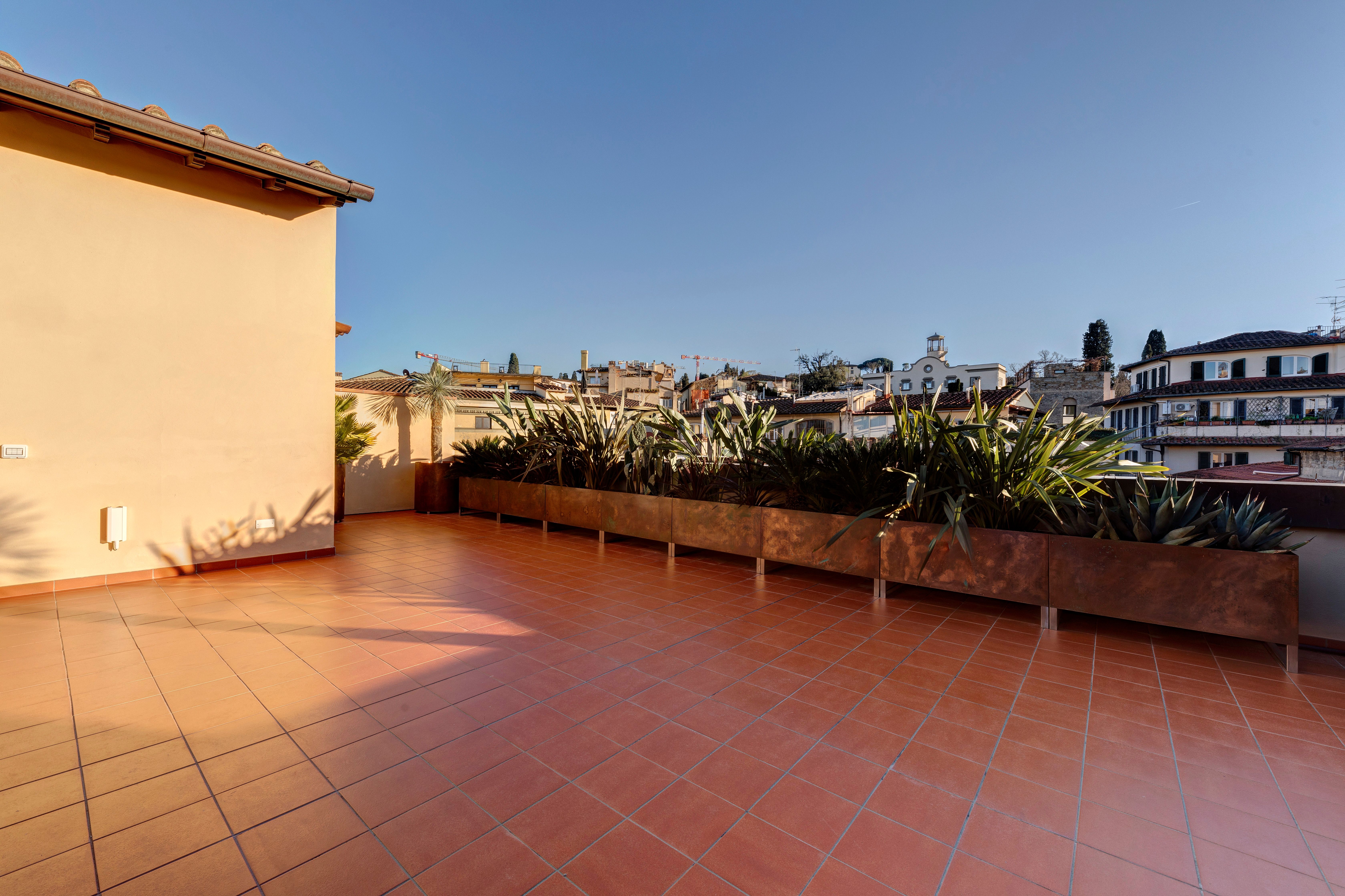 Il terrazzo in cotto, le fioriere in rame lungo il parapetto