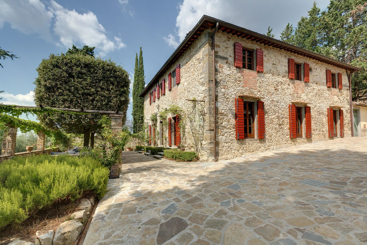 La casa dal vialetto, le persiane rosse contro la pietra