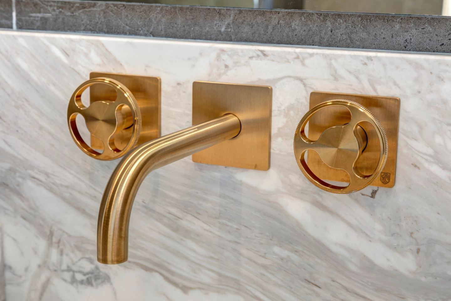 Brass wall mixer on the marble, close