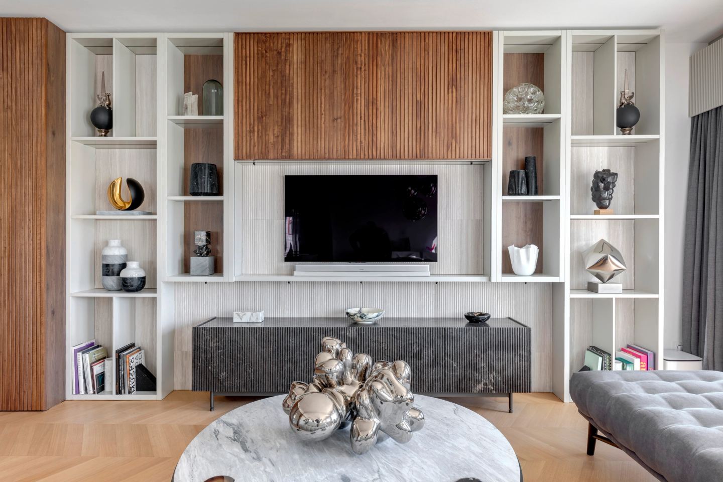 The same wall with the television revealed behind the walnut panel