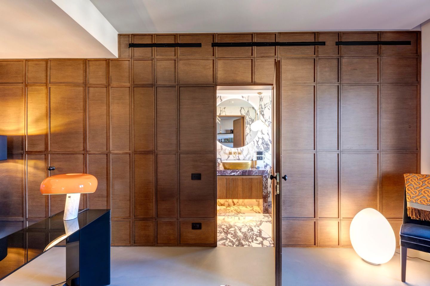 Una porta nella boiserie si apre sul bagno in marmo
