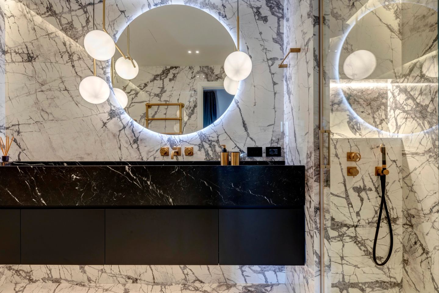 Black stone vanity below the round backlit mirror