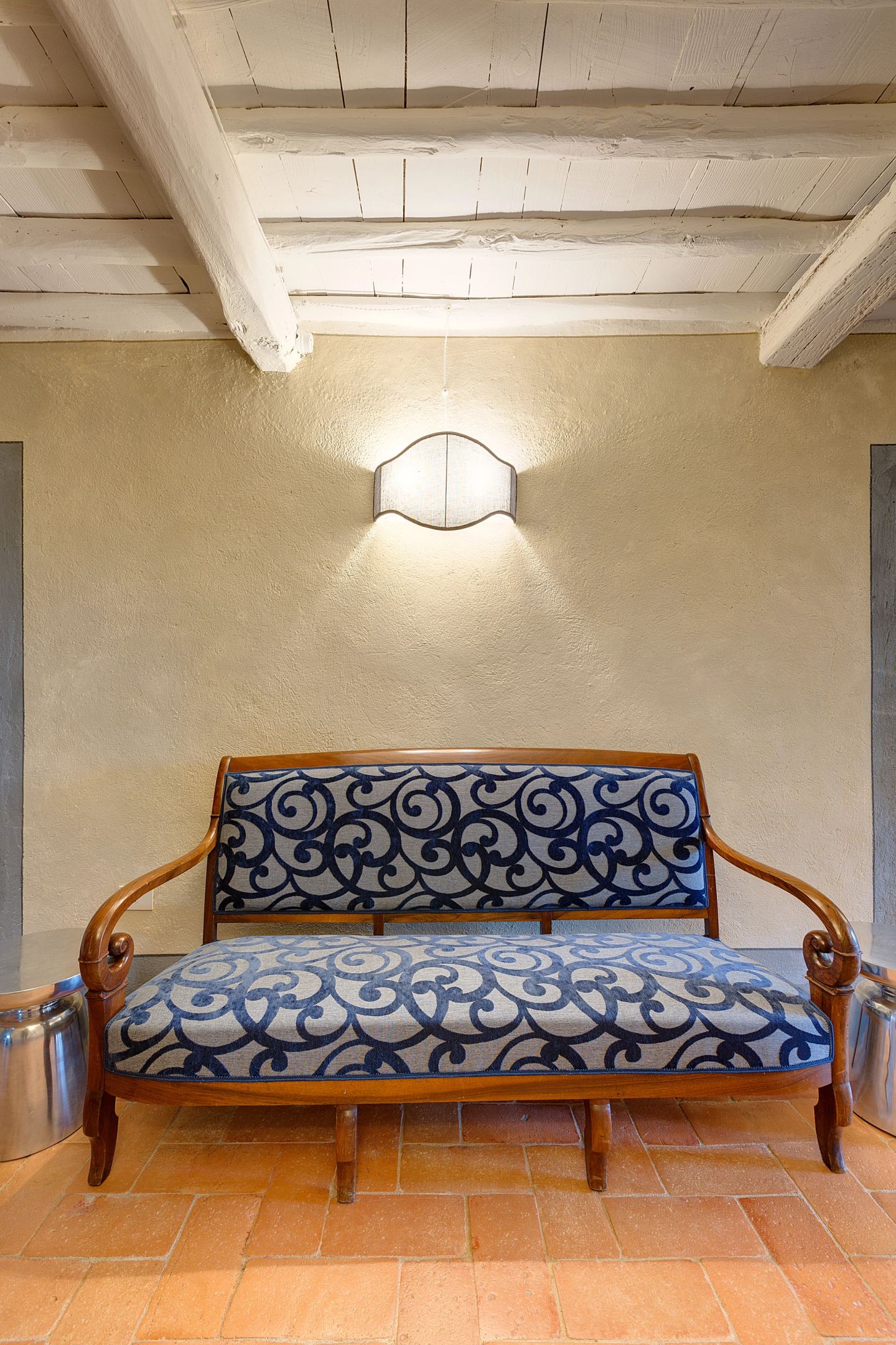 The painted settee against bare plaster