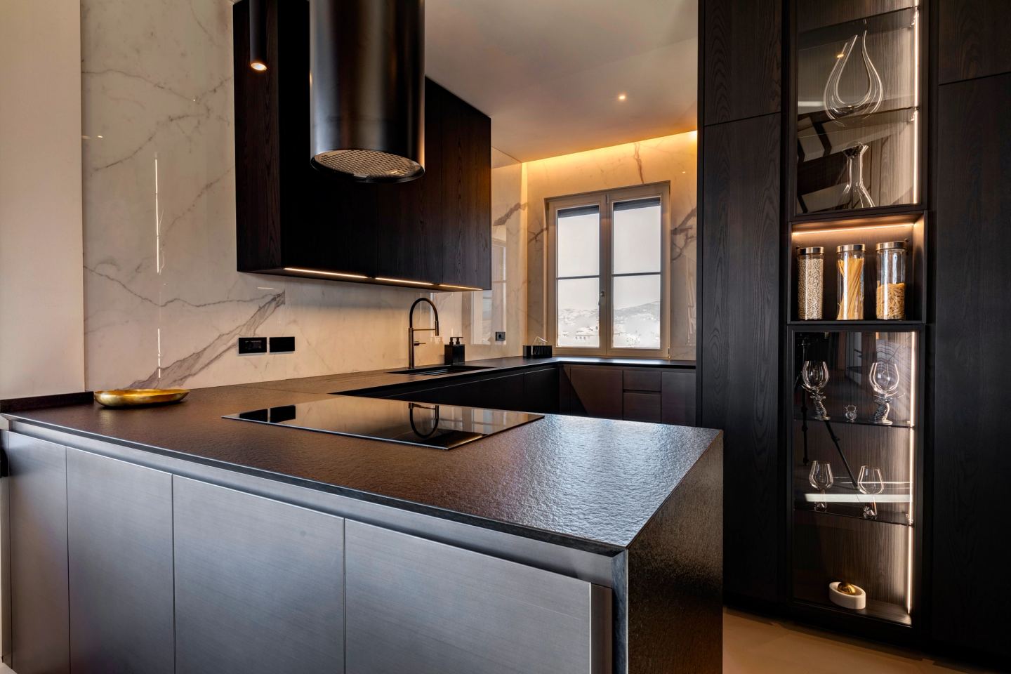 Marble splashback and black worktop, glass cabinet to the right