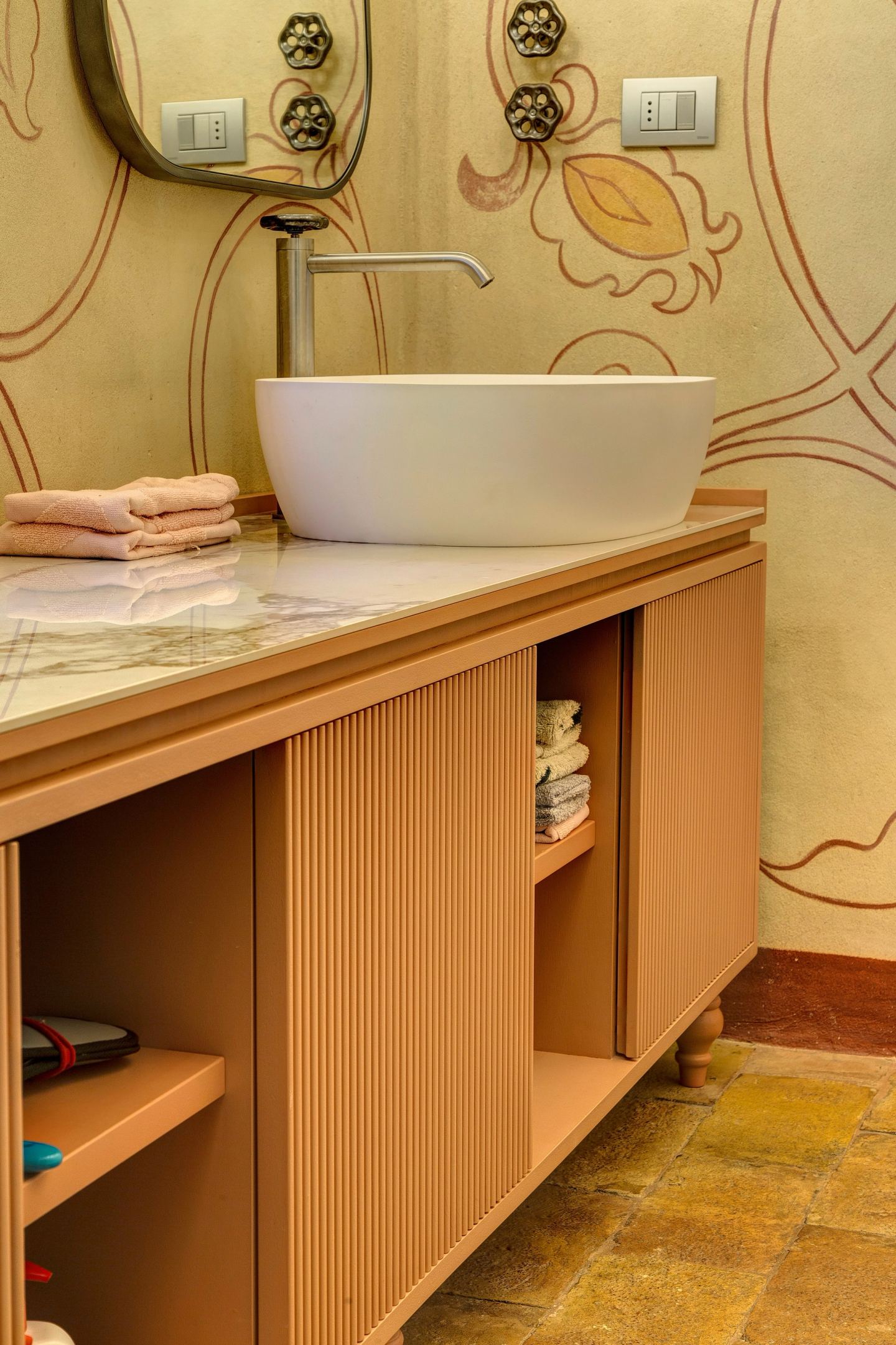 The fluted cabinet in a warm terracotta tone, open shelves at the end