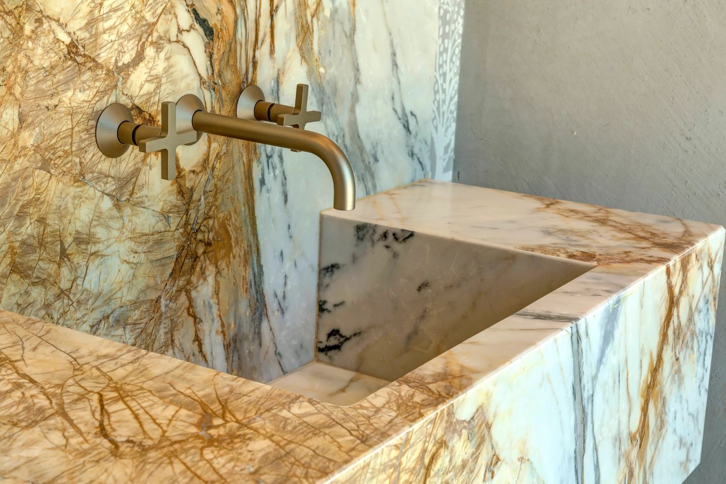 The basin cut into the marble, the tap above it
