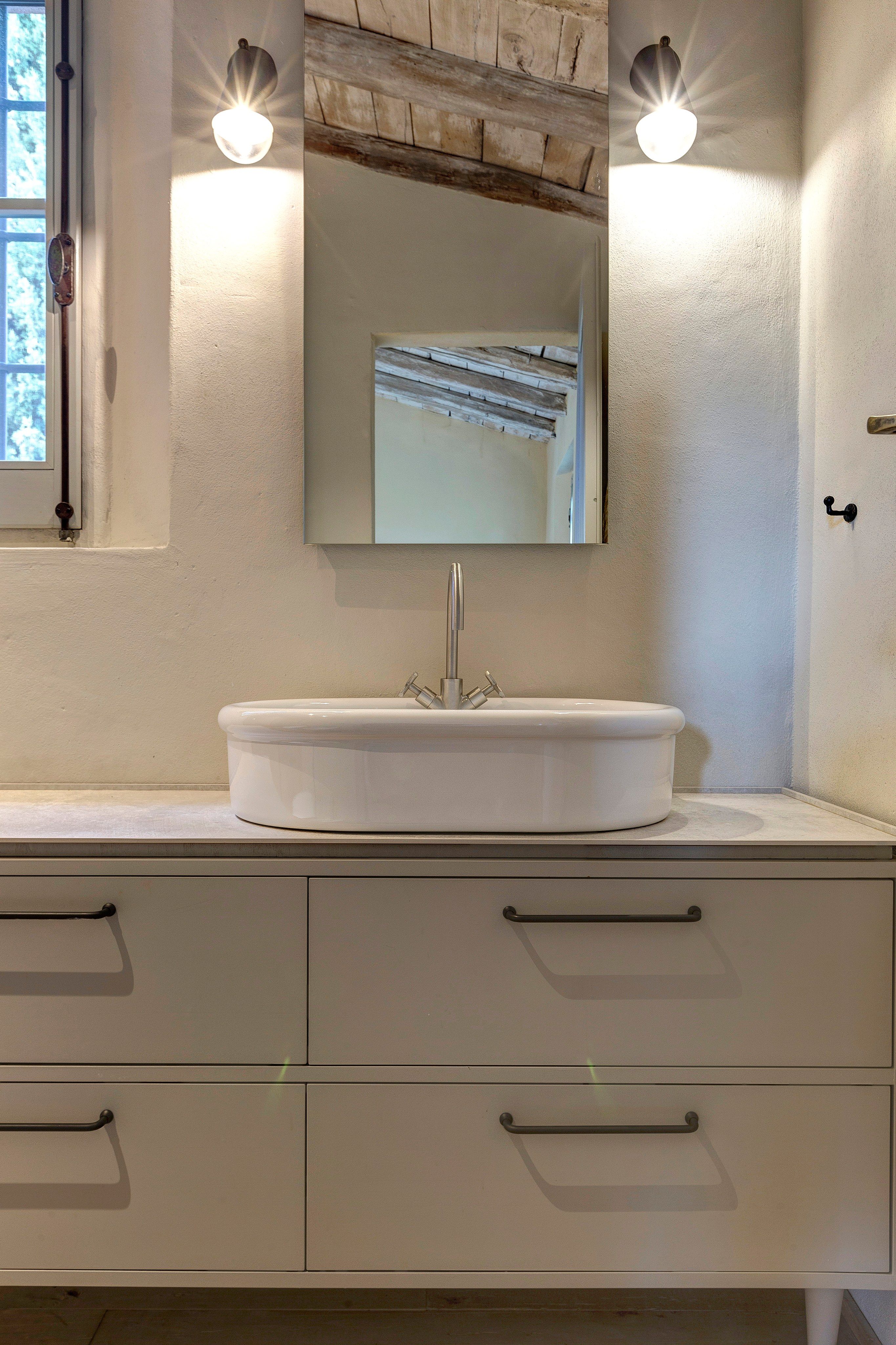 The oval basin, the mirror and two wall lights