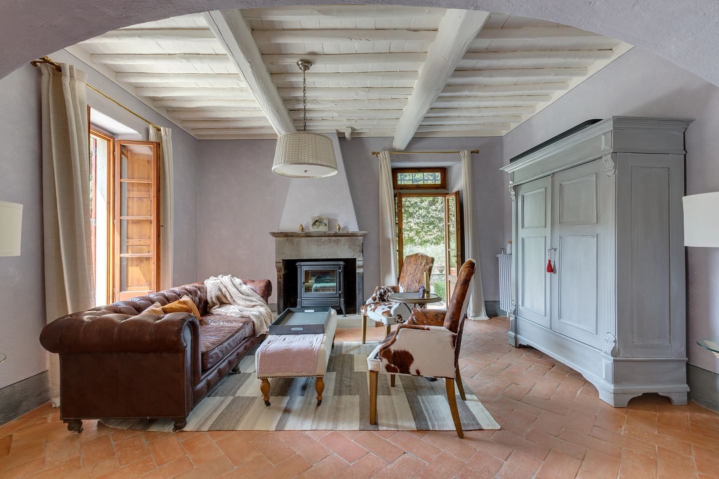 The leather sofa drawn up to the hearth