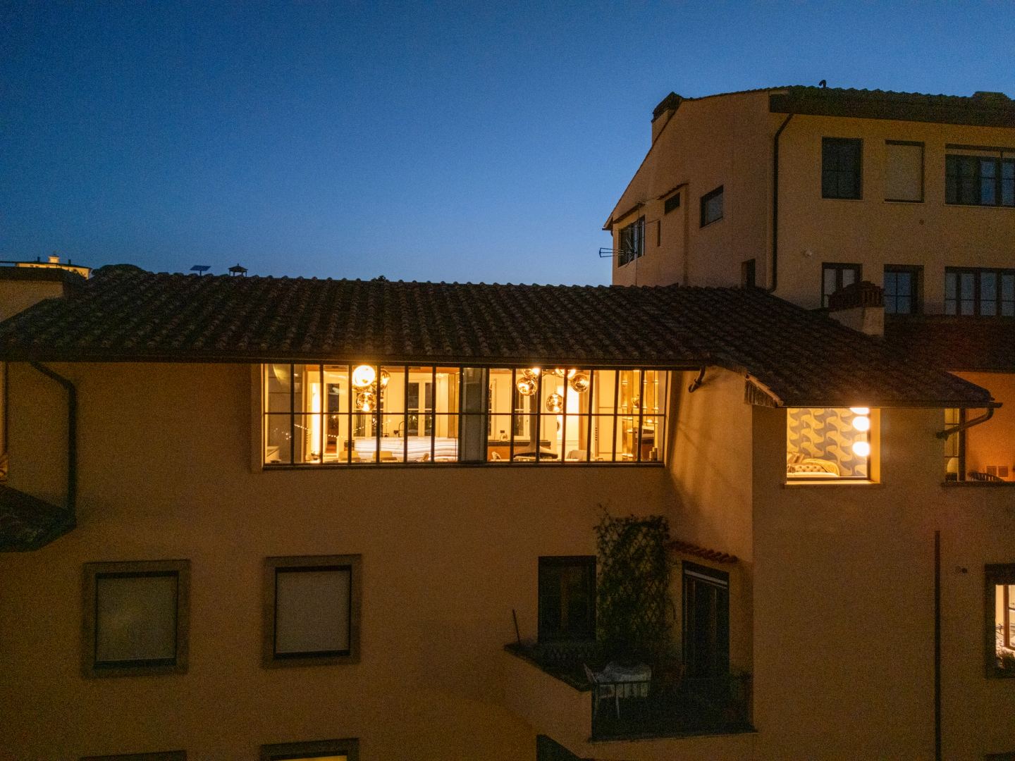 The apartment's windows alight under the eaves at night