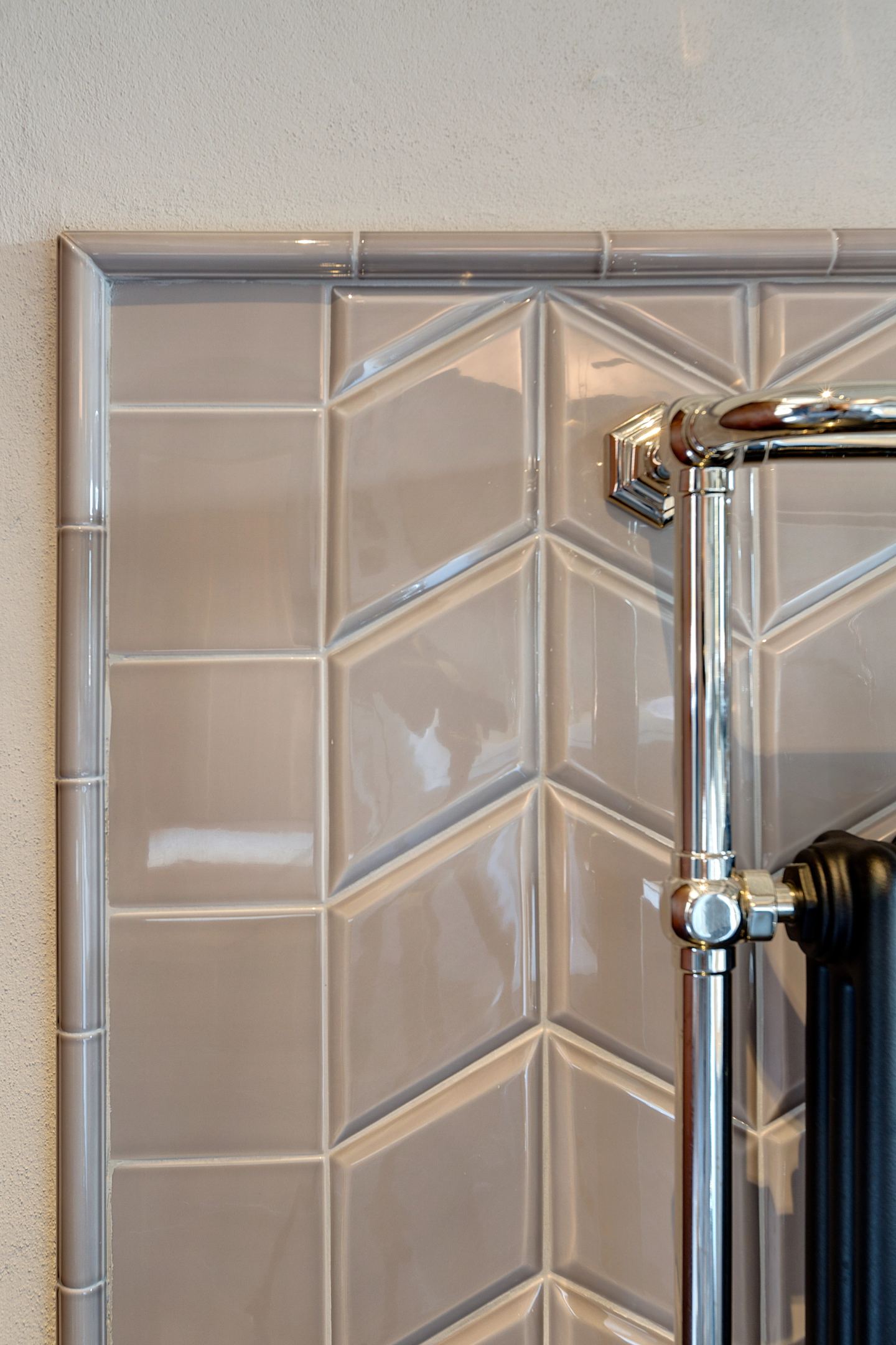The shower riser against the chevron wall