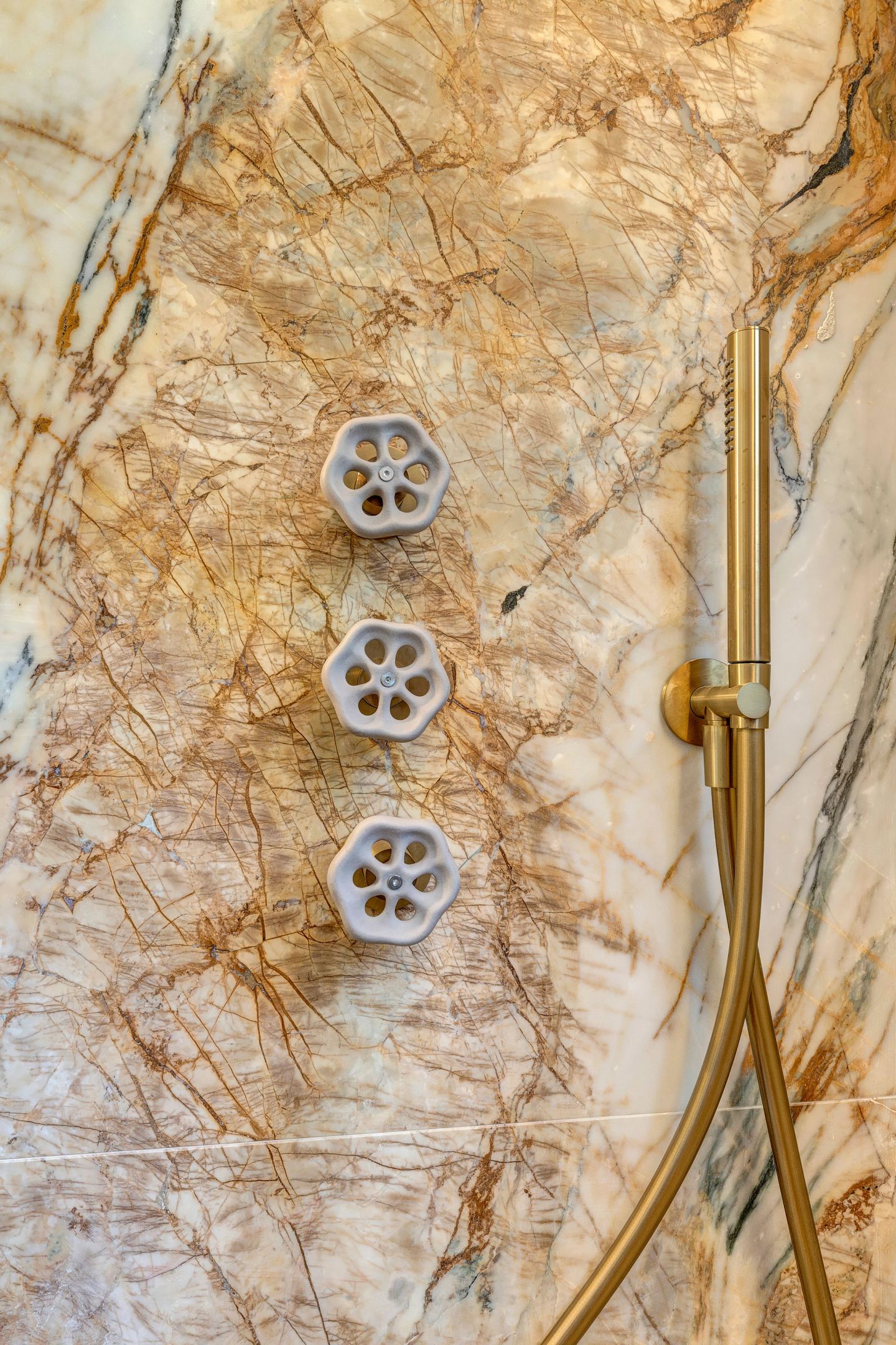Three brass controls on the veined stone