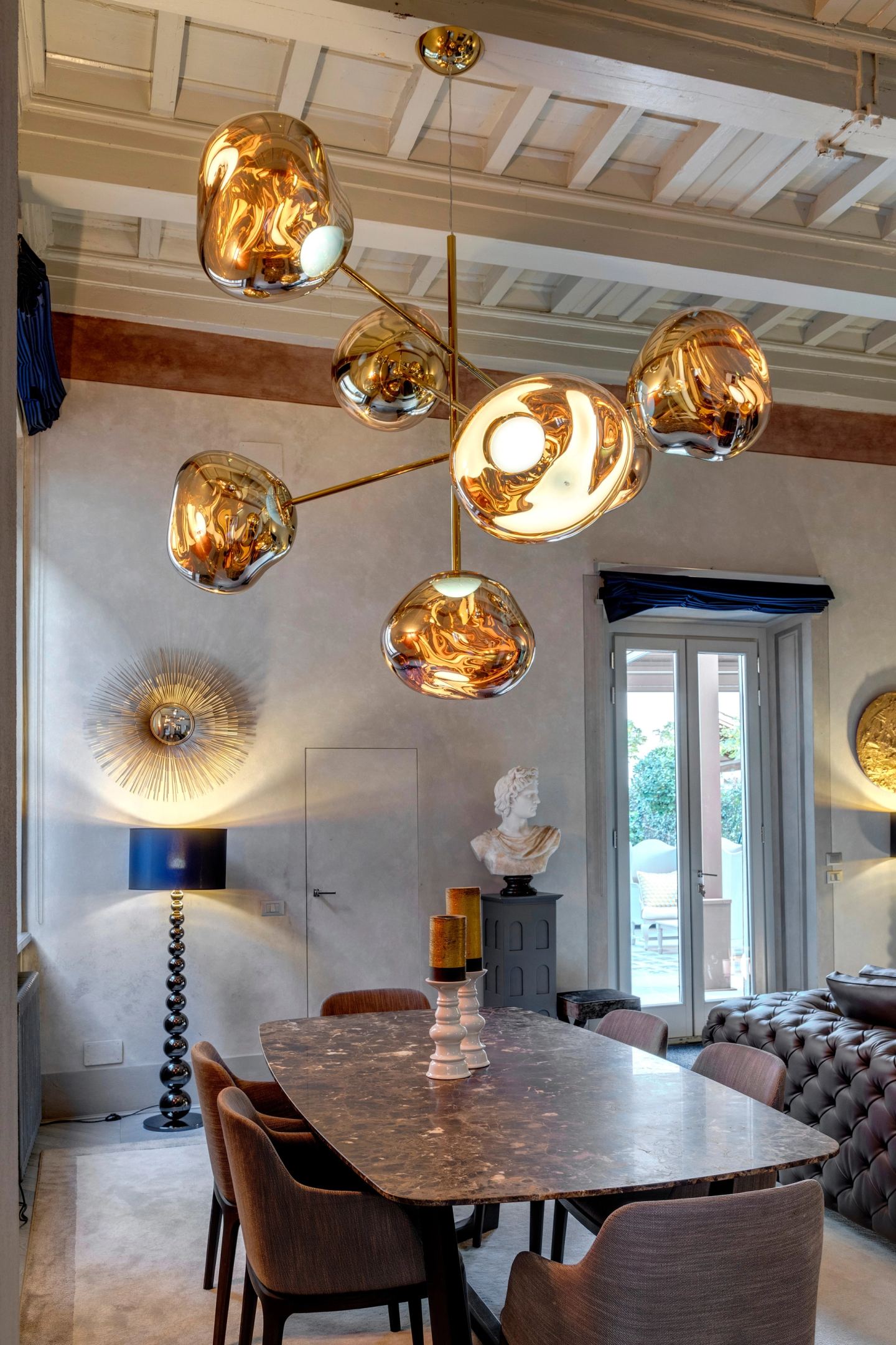 The chandelier over the dining table, the tall window behind
