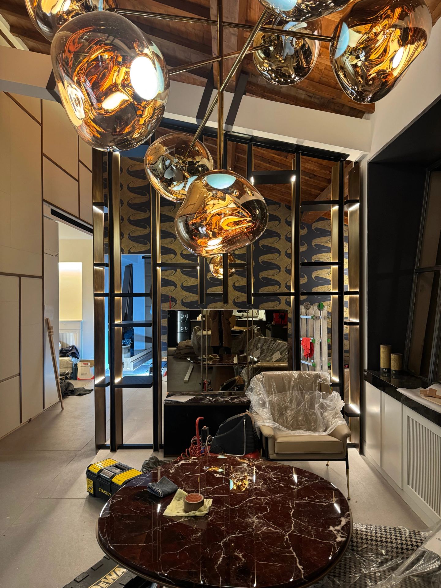 The copper globes lit over the marble table, the library beyond