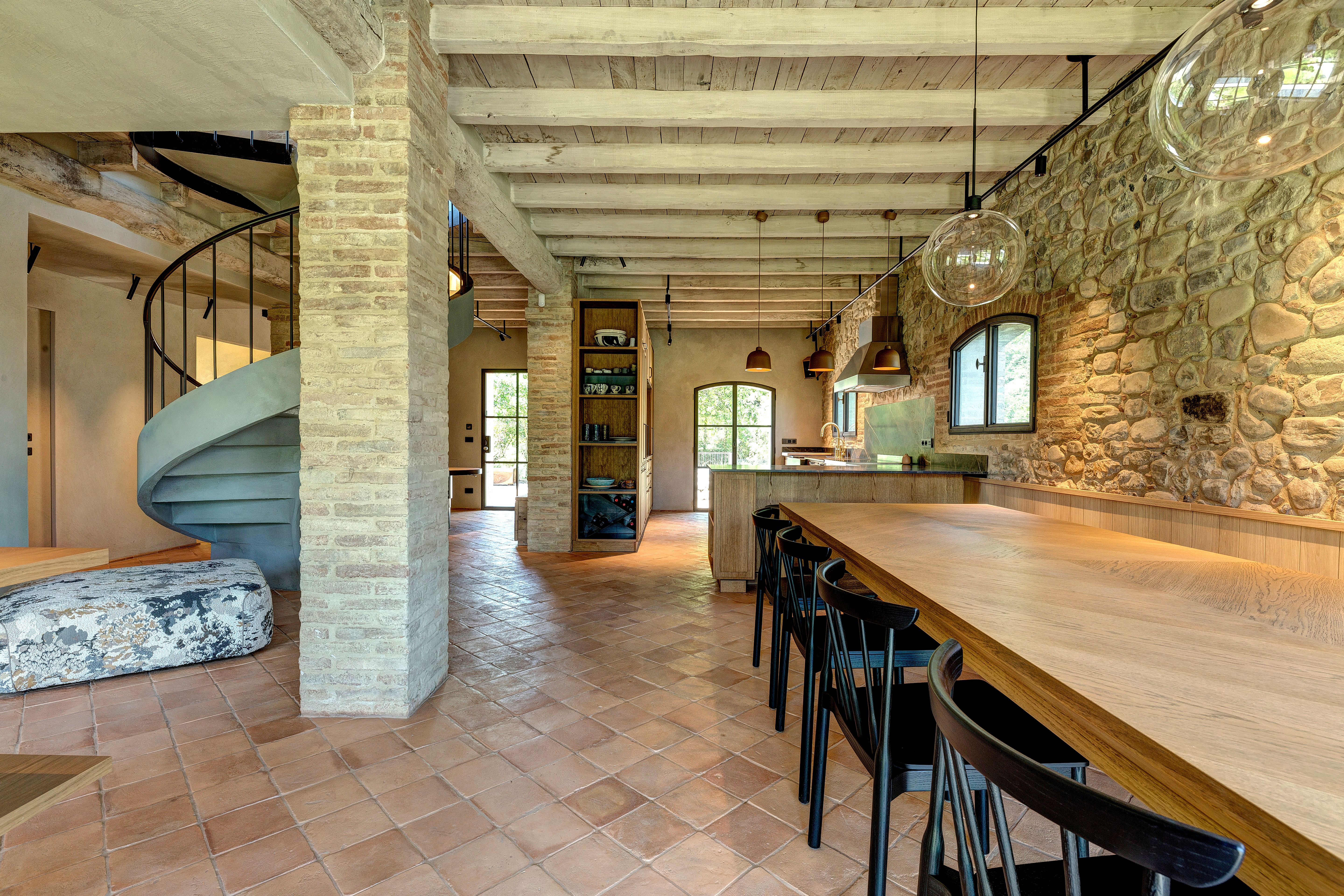The long table under the beams, the stair turning beyond it