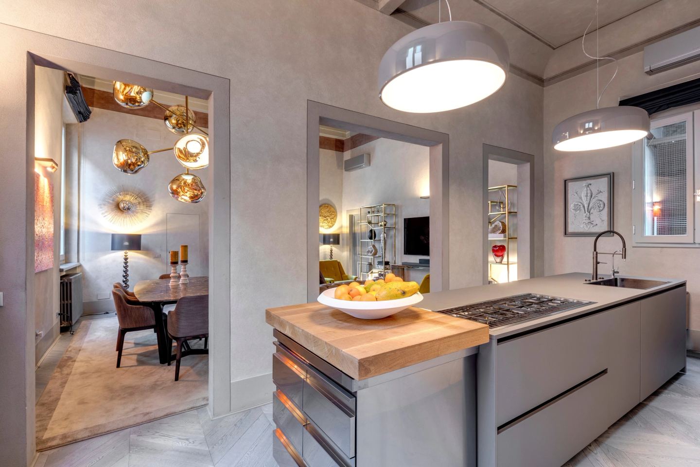 The kitchen island under two wide pendants, the dining room through the door