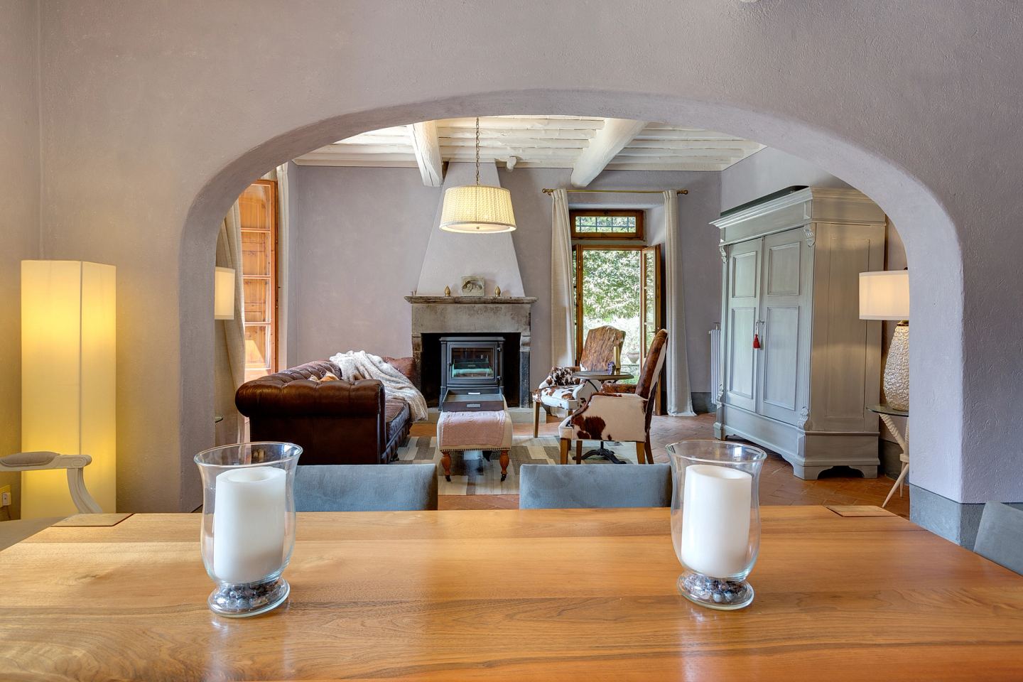 Candles on the table, the arch framing the fire