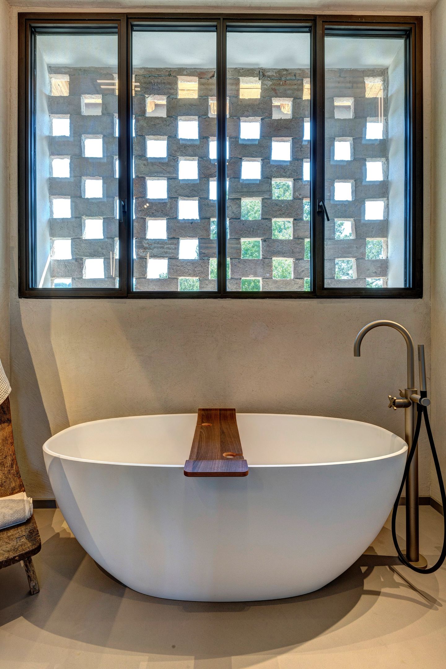 The bath below the window, a tray across it