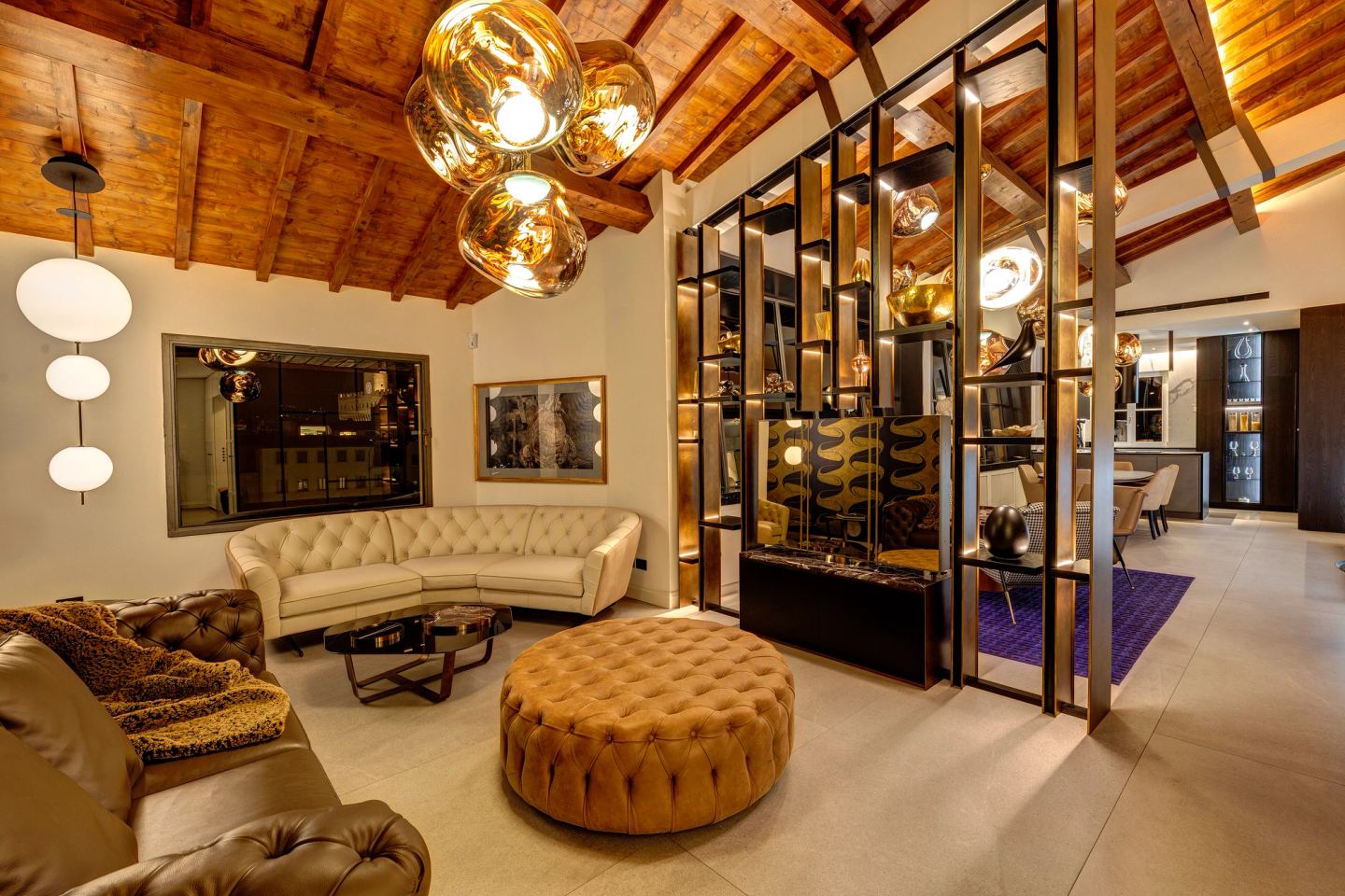 Curved sofa and ottoman with the city dark beyond the glass