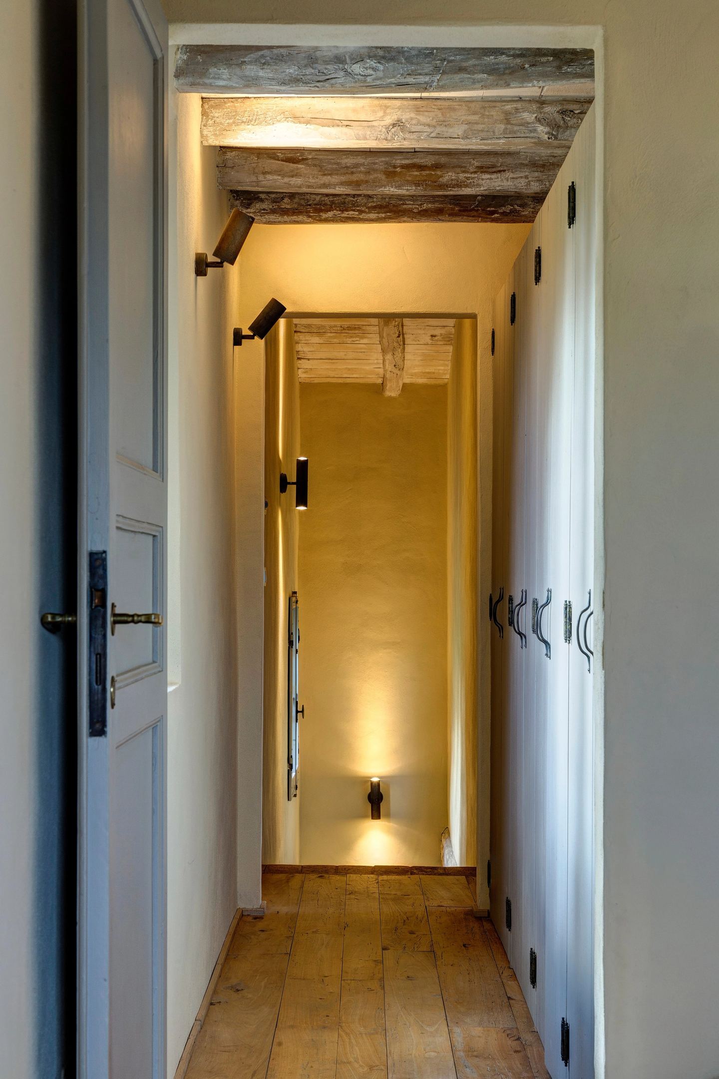 The repainted wardrobes and a wall light at the end of the corridor
