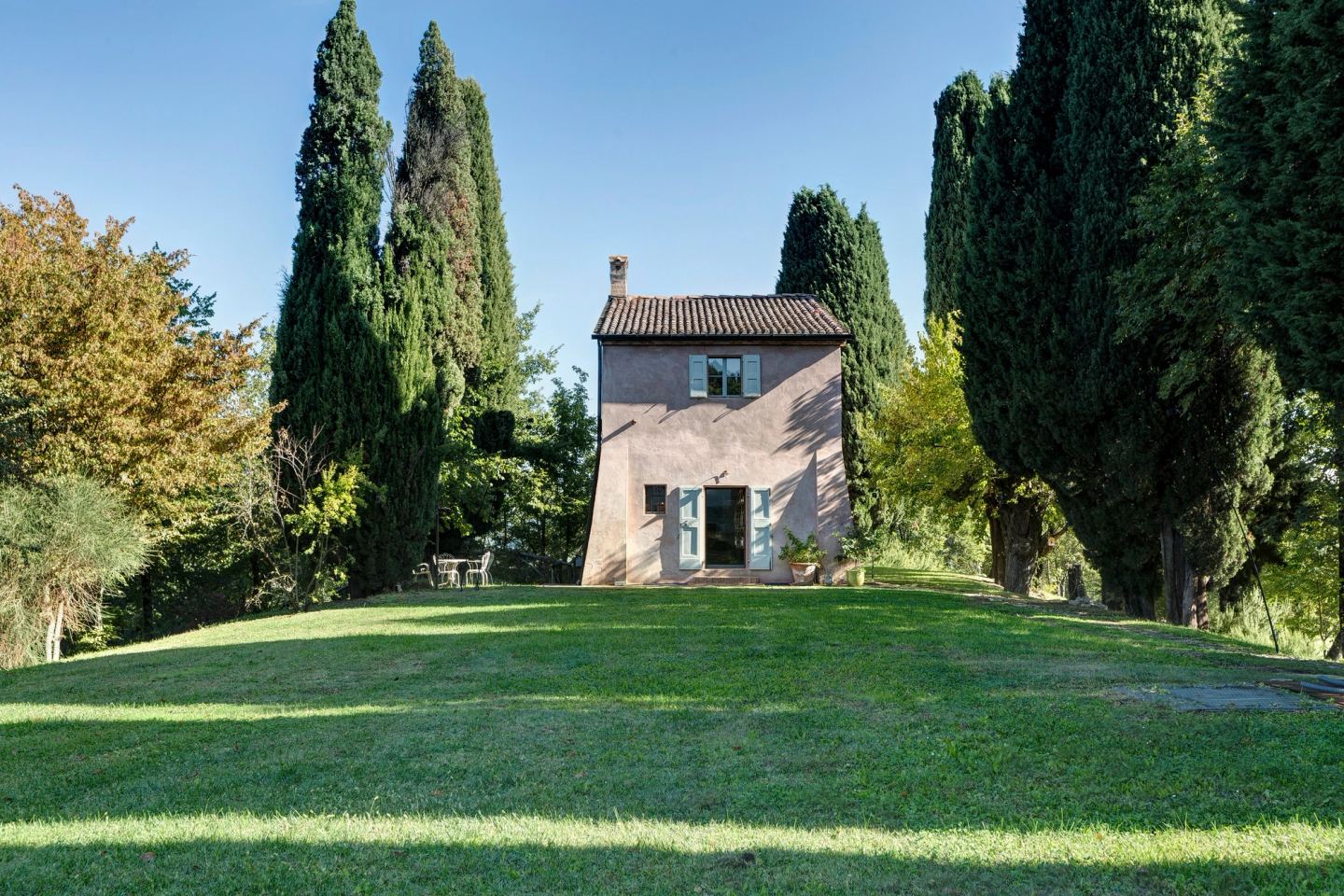 La GuestHouse in cima al prato, incorniciata dai cipressi