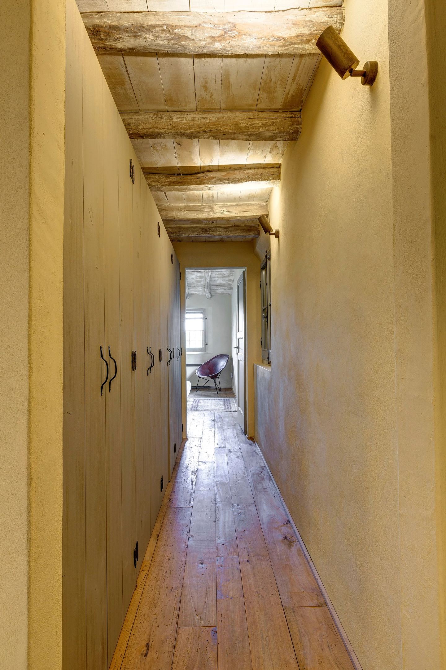 The long corridor, wardrobes along one wall, the floorboards running away
