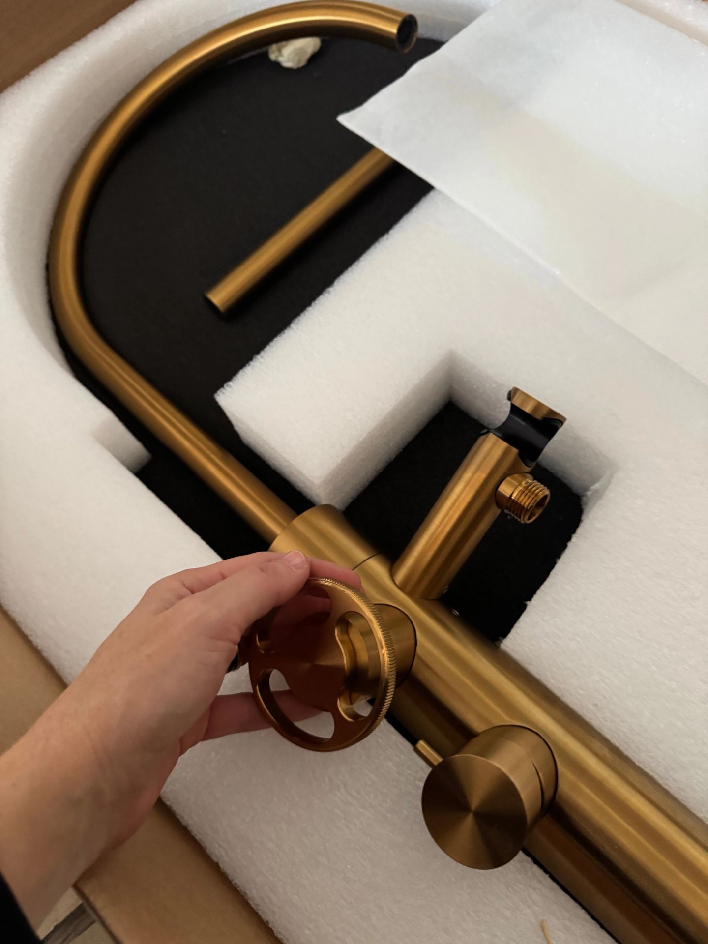 A brushed-brass tap out of its packaging