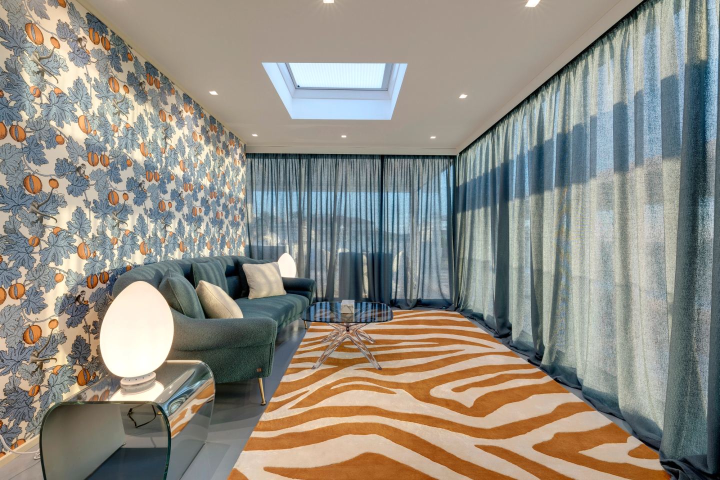 Sofa and armchairs on the patterned rug, curtains drawn