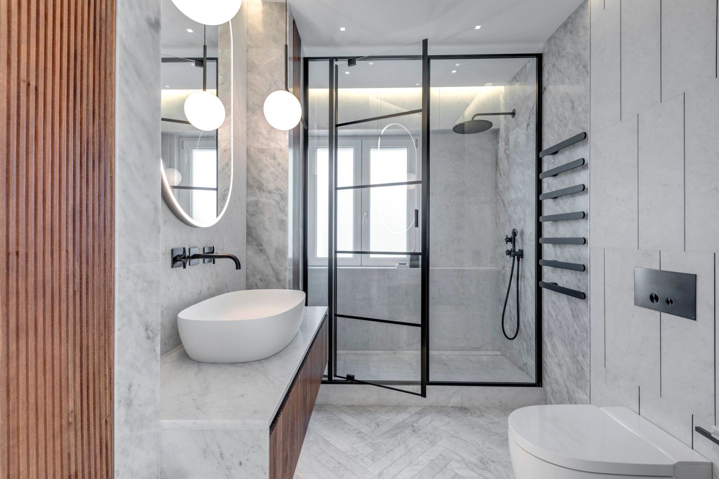 The bathroom from the door: vanity, walk-in shower, herringbone marble floor