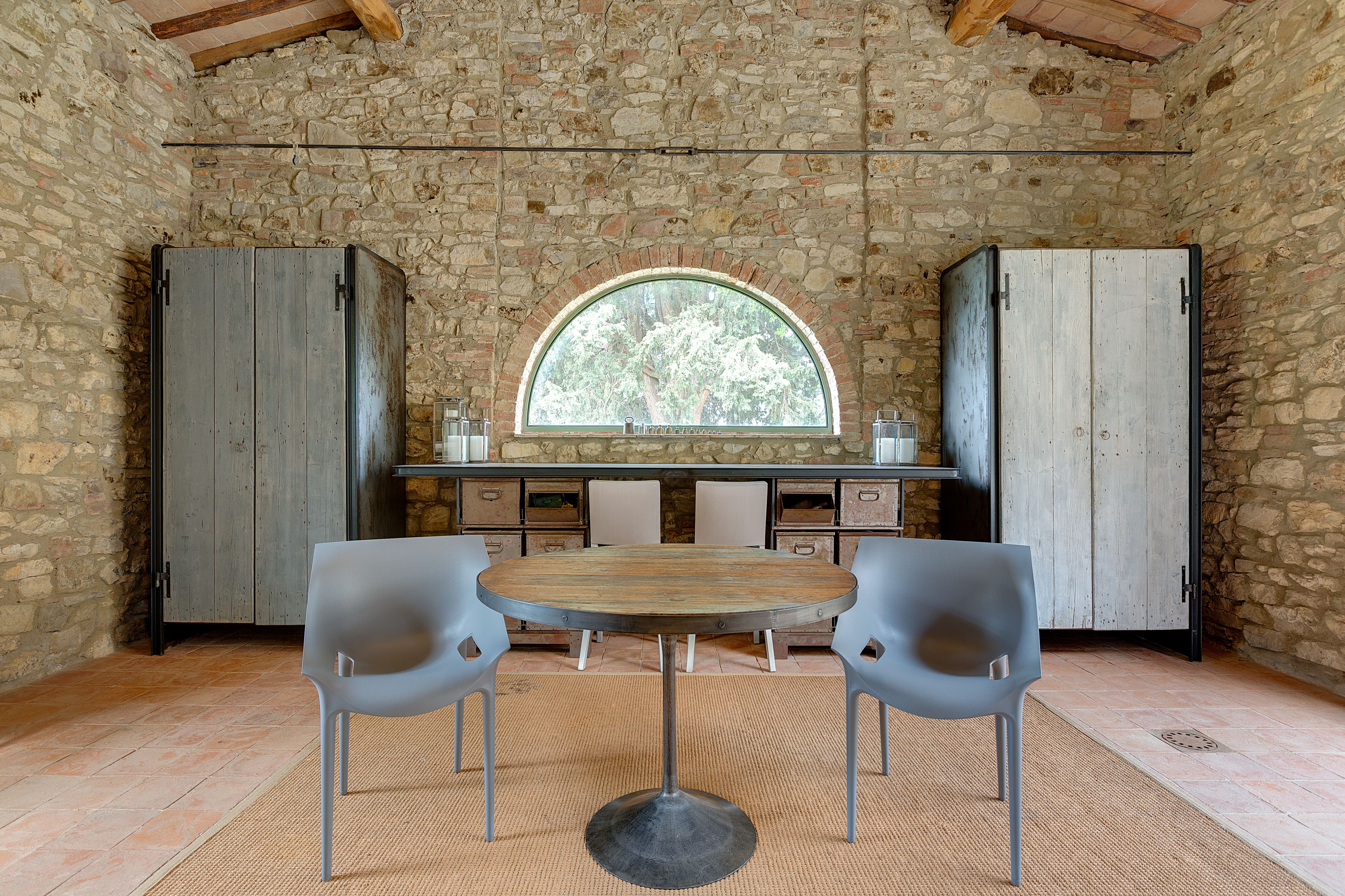 The round table set between the corten cupboards