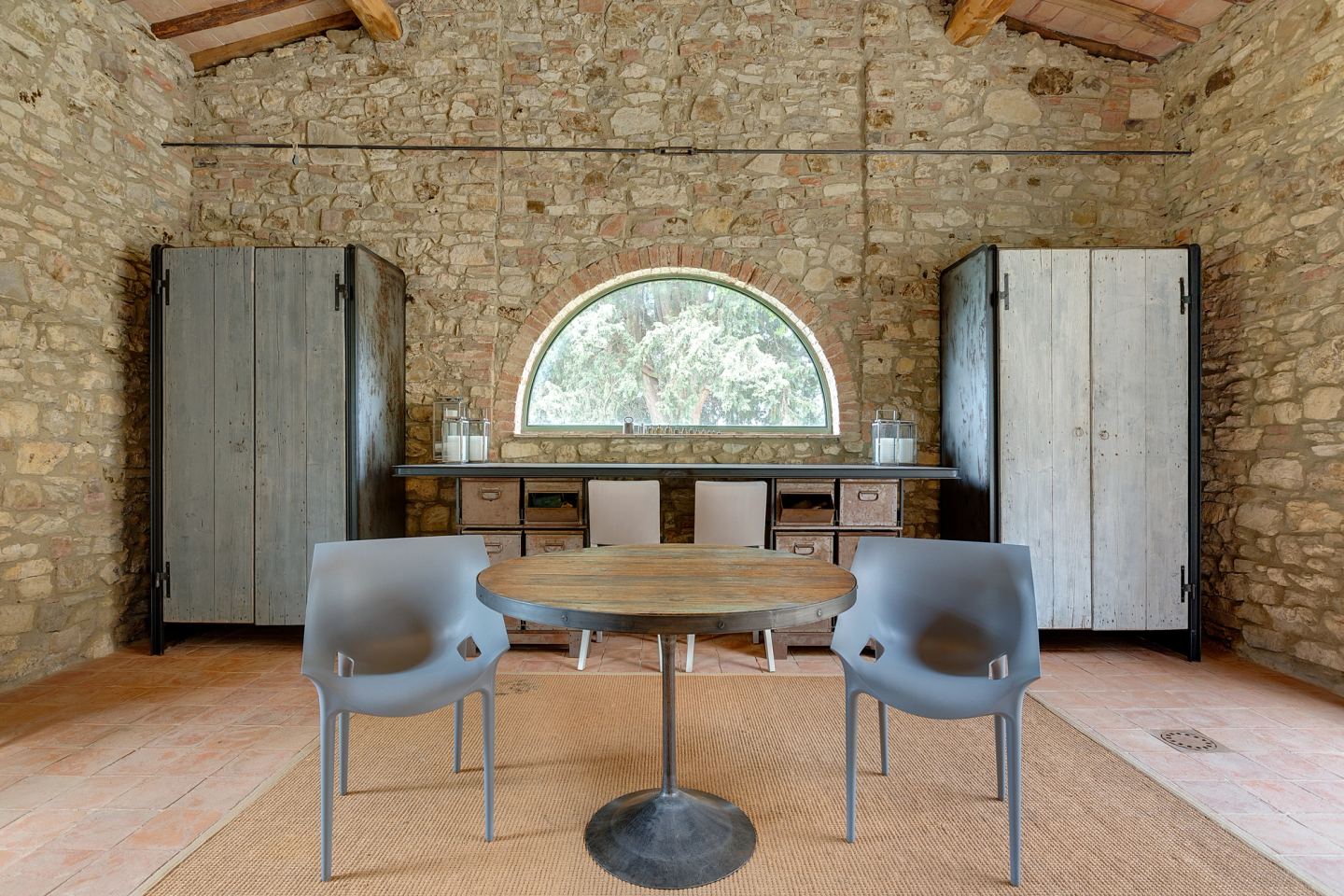 The round table set between the corten cupboards