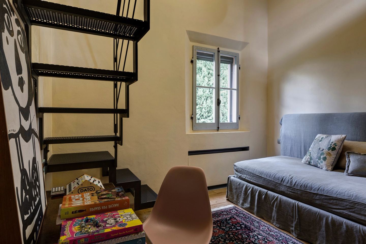 The loft bedroom: the ottoman bed below, the iron stair rising beside it