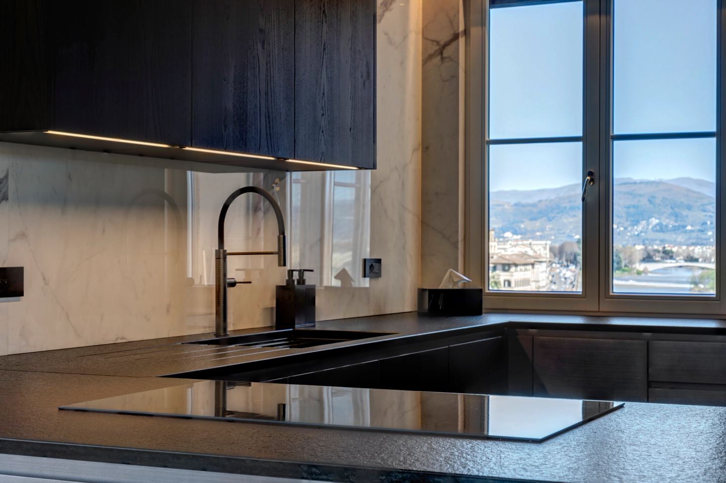 The induction hob set flush into the black stone