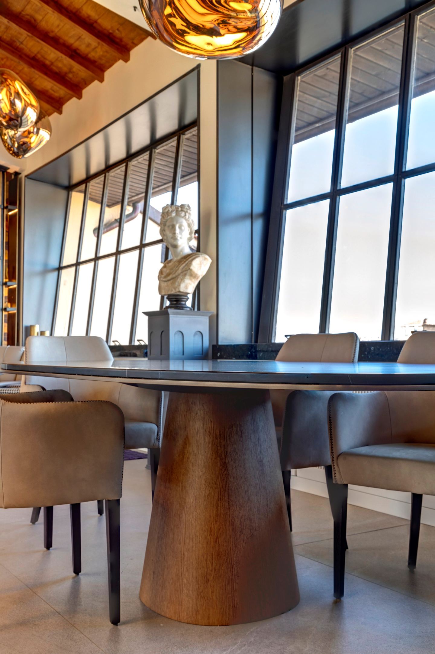 Dining chairs and the bust against the window wall