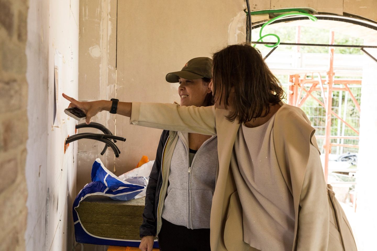 Deniz Önel and Rebecca at a wall, pointing out a detail