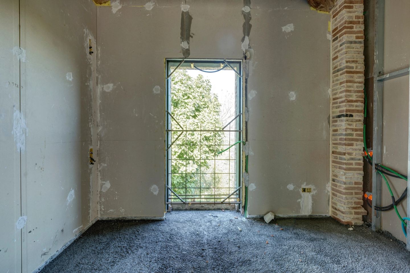 A tall narrow opening, the green beyond