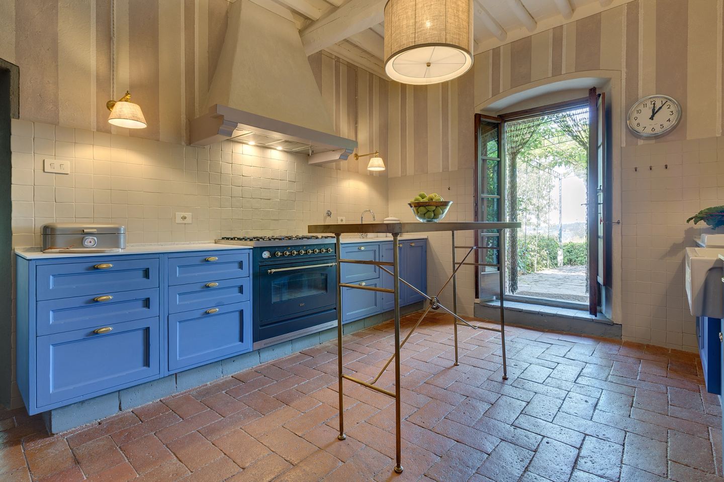 Blue cabinetry against the terracotta floor