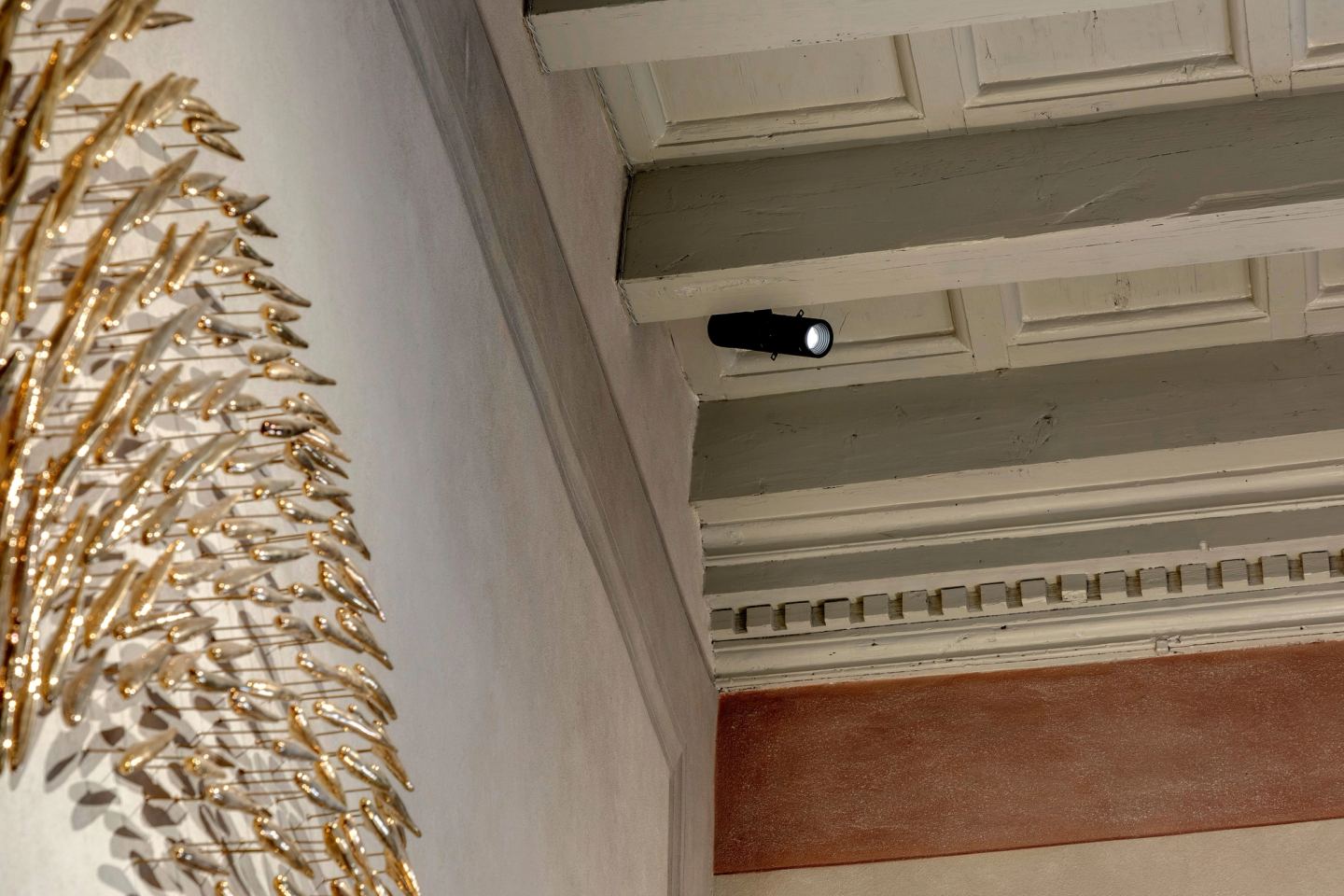 A small spotlight set on a ceiling beam
