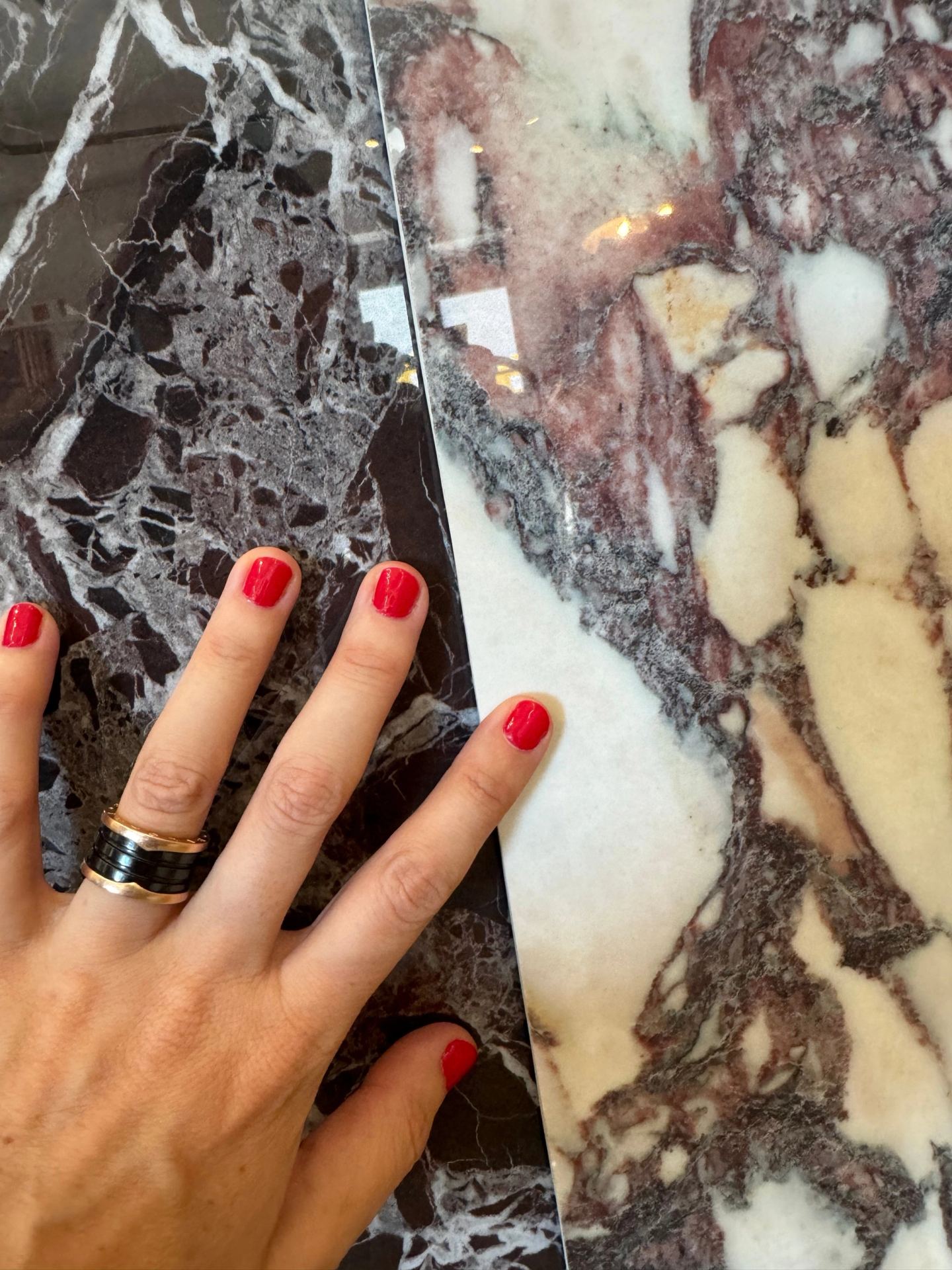 Two marbles side by side, a hand for scale